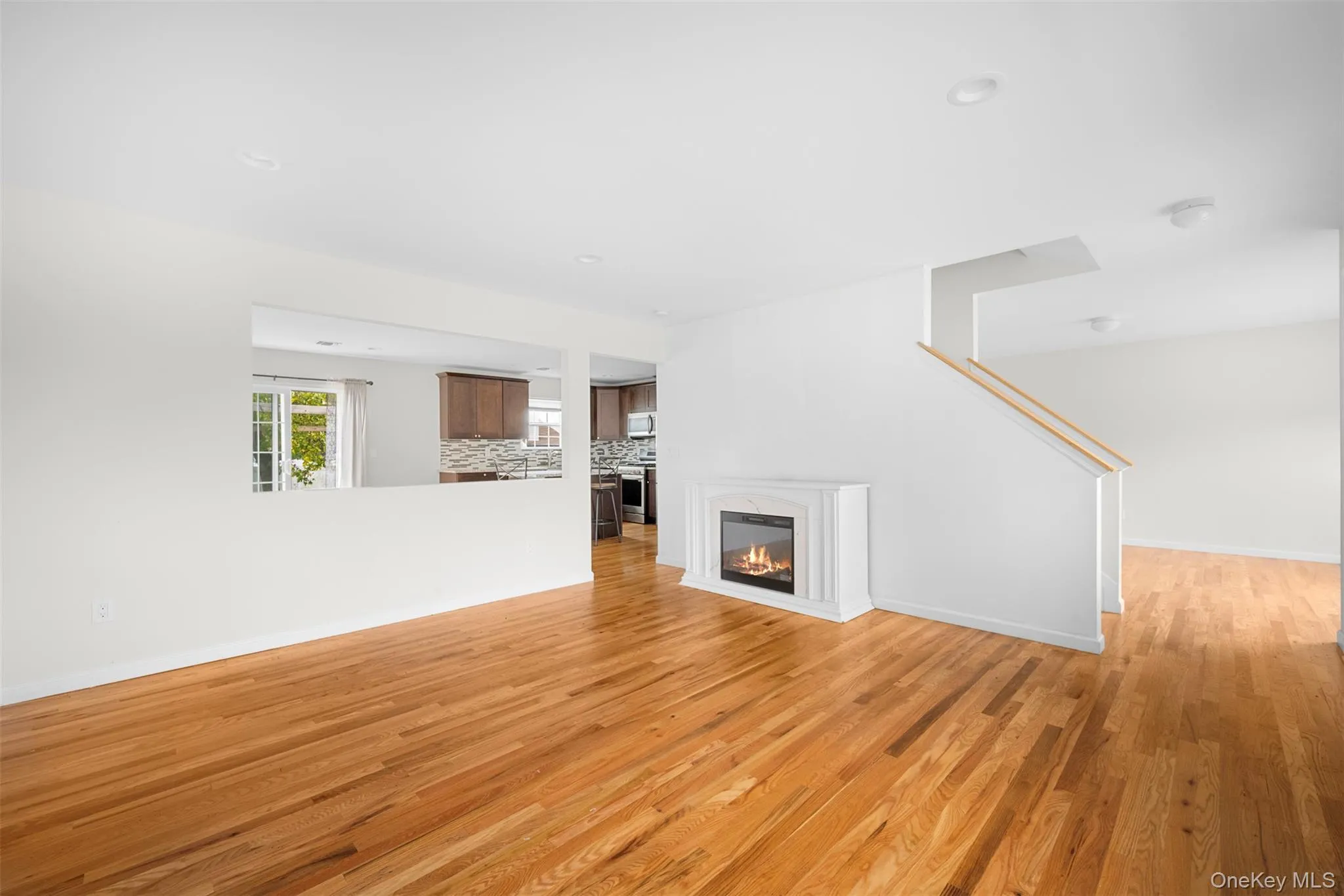 Unfurnished living room featuring a glass covered fireplace, light wood finished floors, and recessed lighting Unfurnished living room featuring a glass covered fireplace, light wood finished floors, and recessed lighting