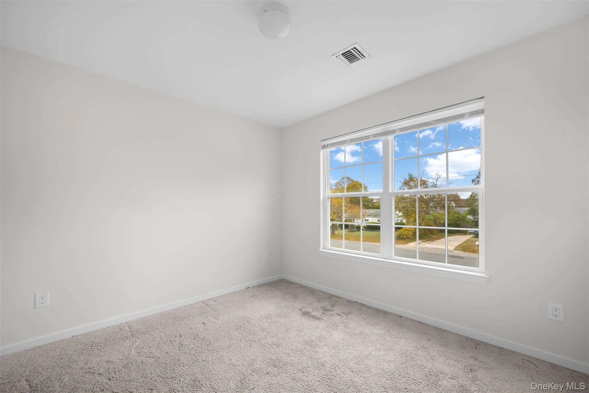 Unfurnished room with carpet flooring and baseboards Unfurnished room with carpet flooring and baseboards