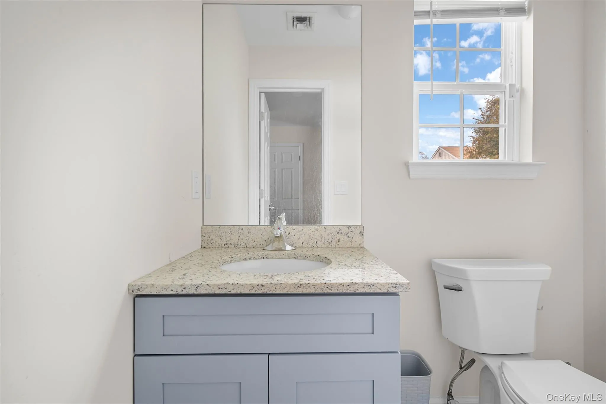 Half bathroom featuring vanity and toilet Half bathroom featuring vanity and toilet