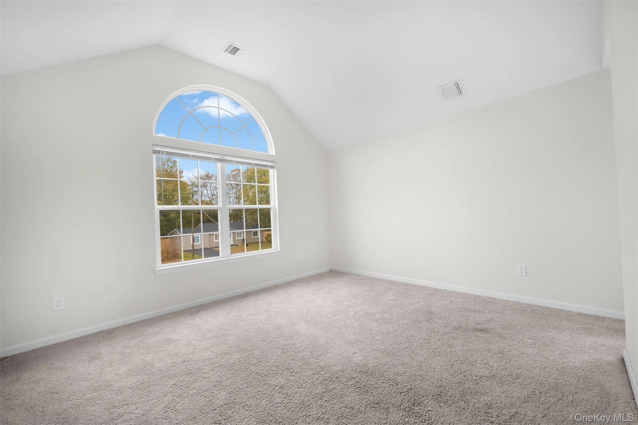 Carpeted spare room featuring lofted ceiling Carpeted spare room featuring lofted ceiling