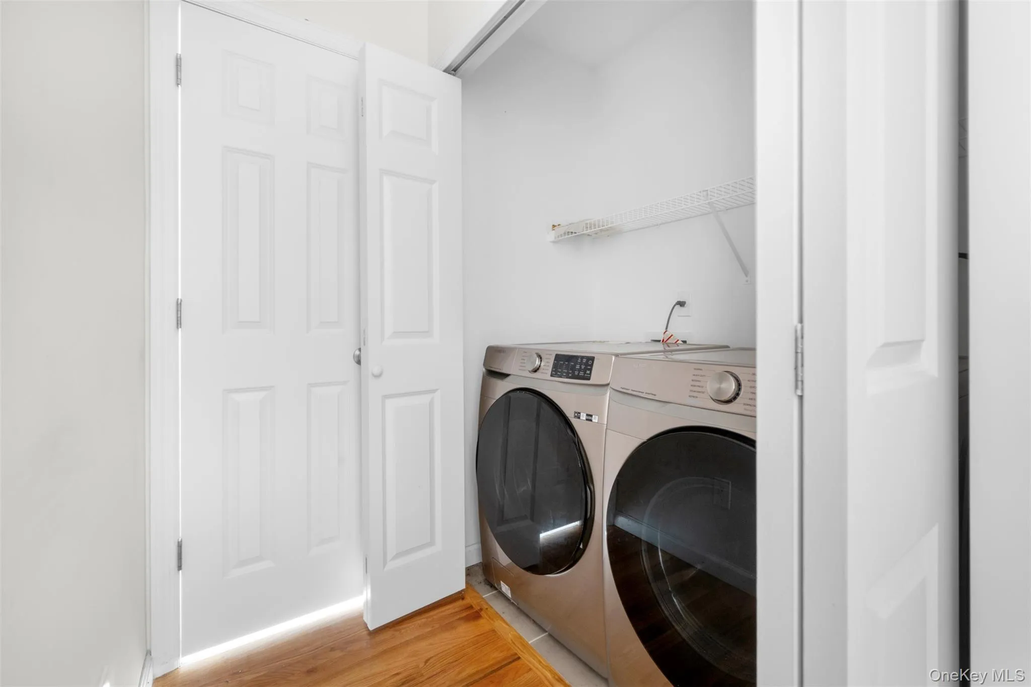Laundry room featuring light wood finished floors and washing machine and clothes dryer Laundry room featuring light wood finished floors and washing machine and clothes dryer