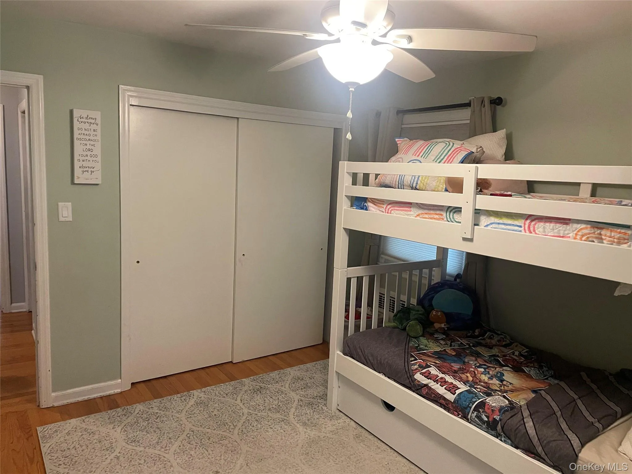 Bedroom featuring wood finished floors, ceiling fan, and a closet Bedroom featuring wood finished floors, ceiling fan, and a closet