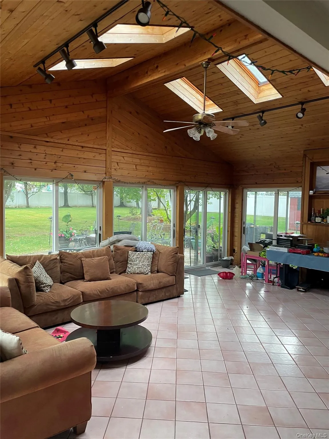 3 Season room with wooden ceiling, track lighting, light tile patterned floors, a skylight, and a ceiling fan 3 Season room with wooden ceiling, track lighting, light tile patterned floors, a skylight, and a ceiling fan