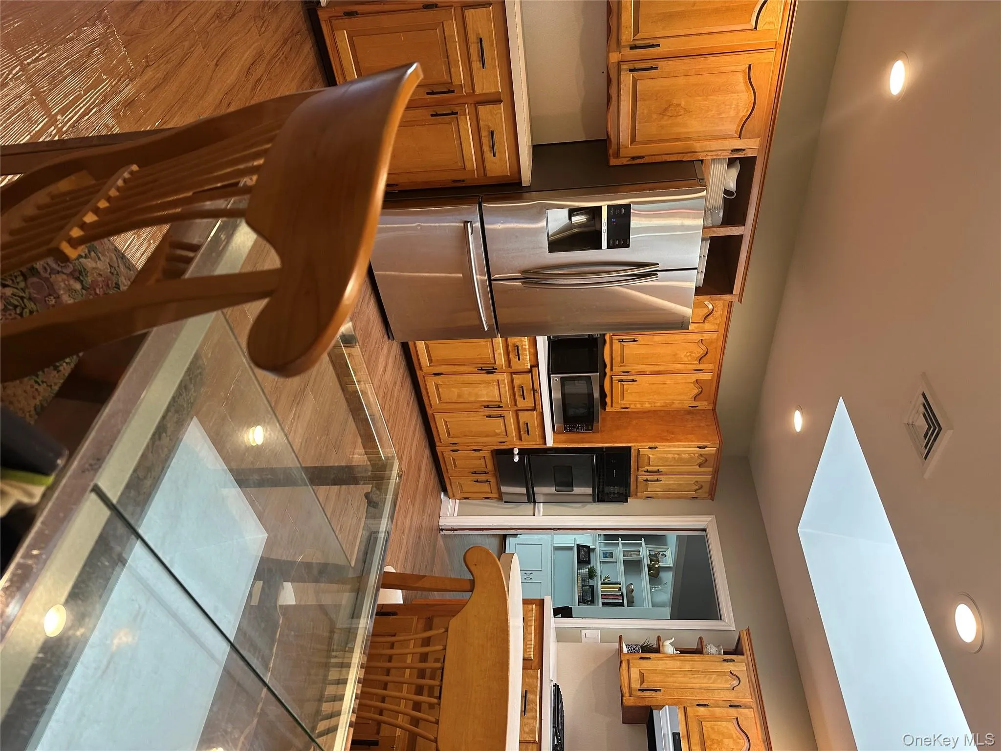 Kitchen with stainless steel appliances, recessed lighting, light countertops, light wood-style floors, and open shelves Kitchen with stainless steel appliances, recessed lighting, light countertops, light wood-style floors, and open shelves