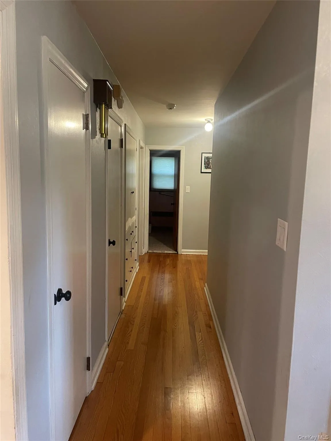 Hallway with light wood-type flooring and baseboards Hallway with light wood-type flooring and baseboards