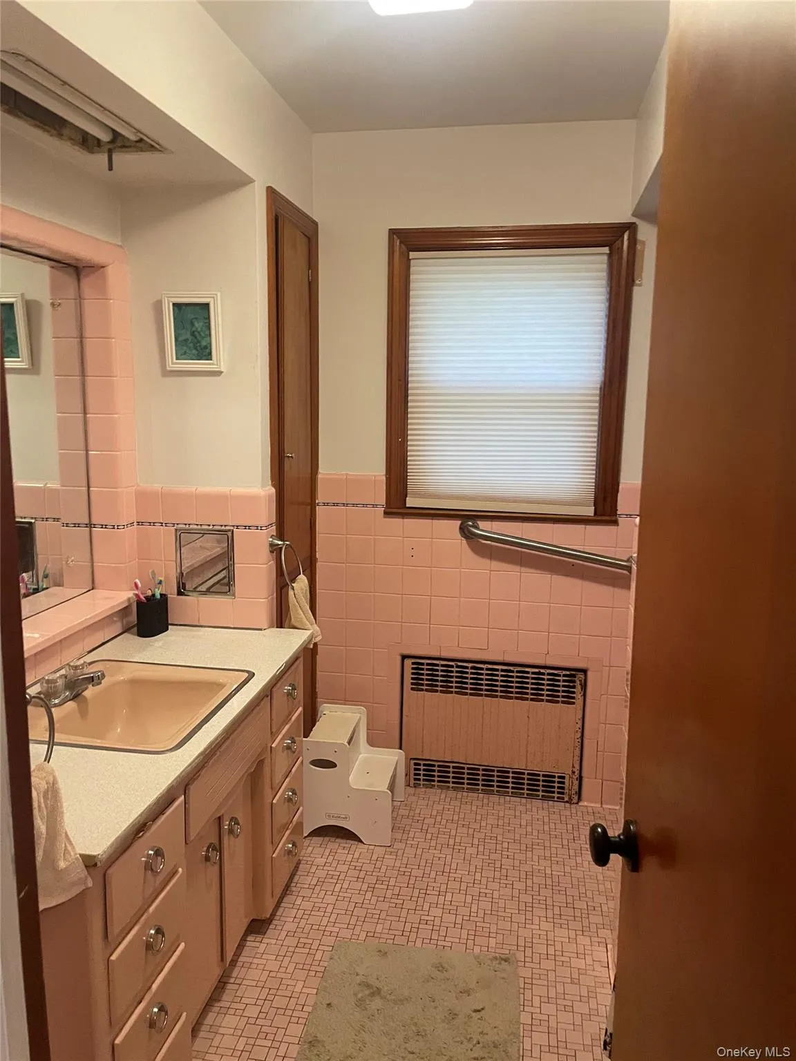 Bathroom featuring vanity, tile walls, radiator heating unit, and a wainscoted wall Bathroom featuring vanity, tile walls, radiator heating unit, and a wainscoted wall