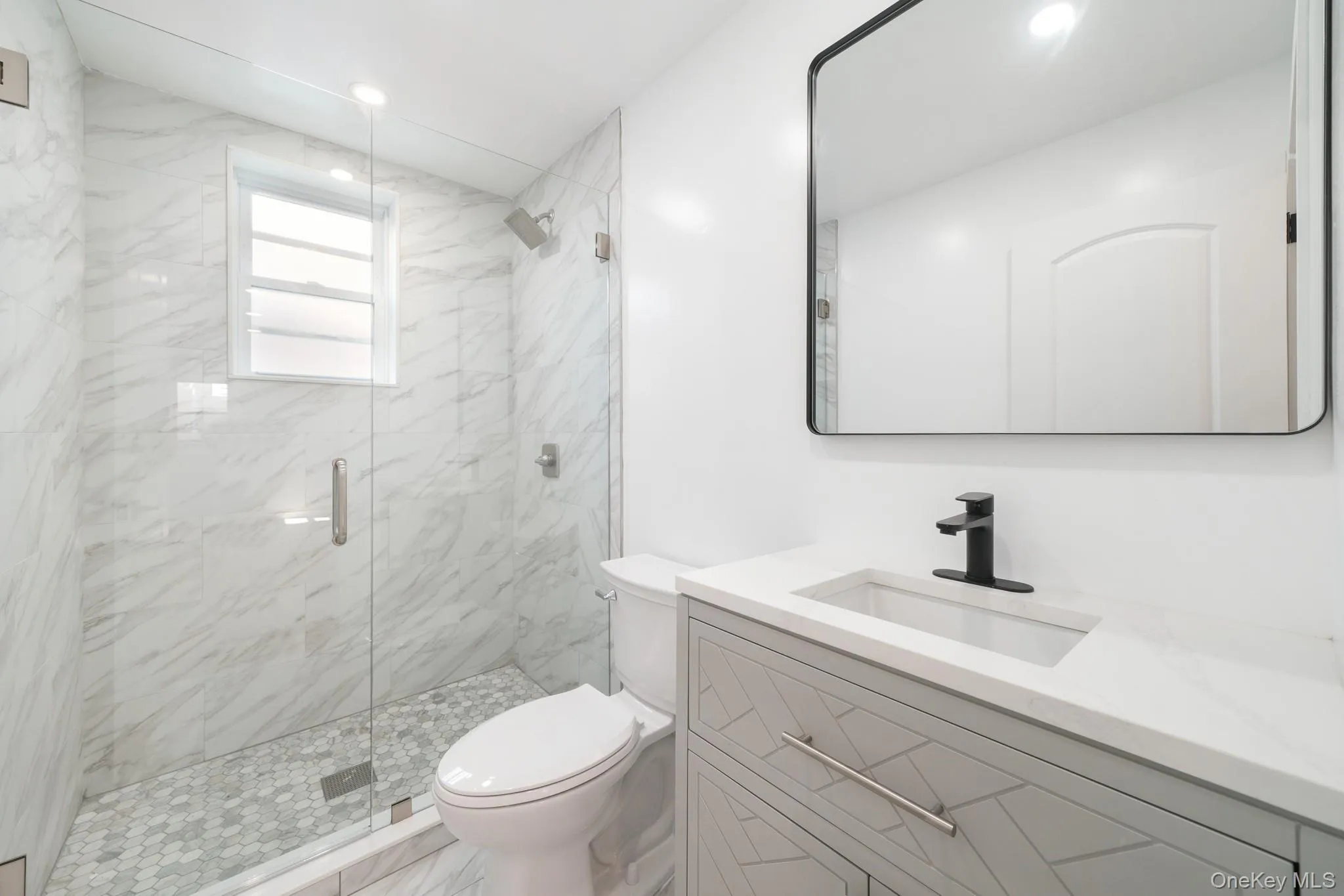Full bath featuring a marble finish shower, vanity, recessed lighting, and marble finish floors Full bath featuring a marble finish shower, vanity, recessed lighting, and marble finish floors