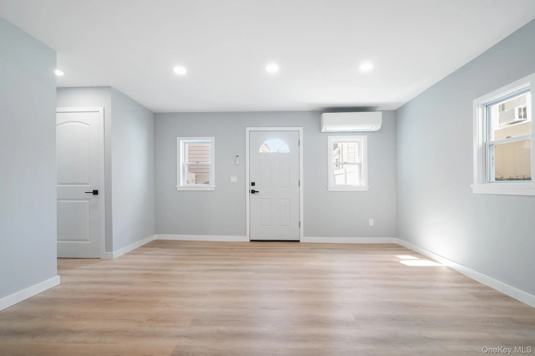 Foyer with light wood-style floors, recessed lighting, and an AC wall unit Foyer with light wood-style floors, recessed lighting, and an AC wall unit