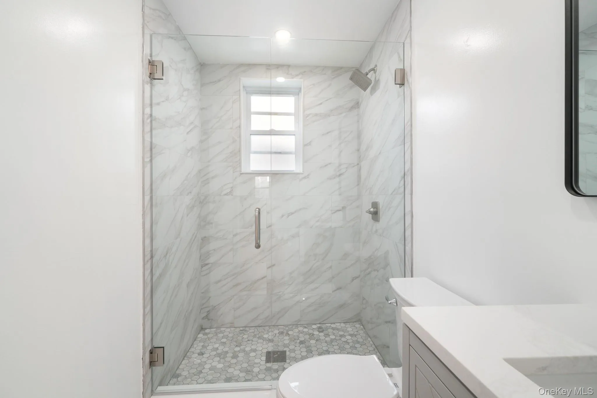 Full bathroom featuring a marble finish shower and vanity Full bathroom featuring a marble finish shower and vanity