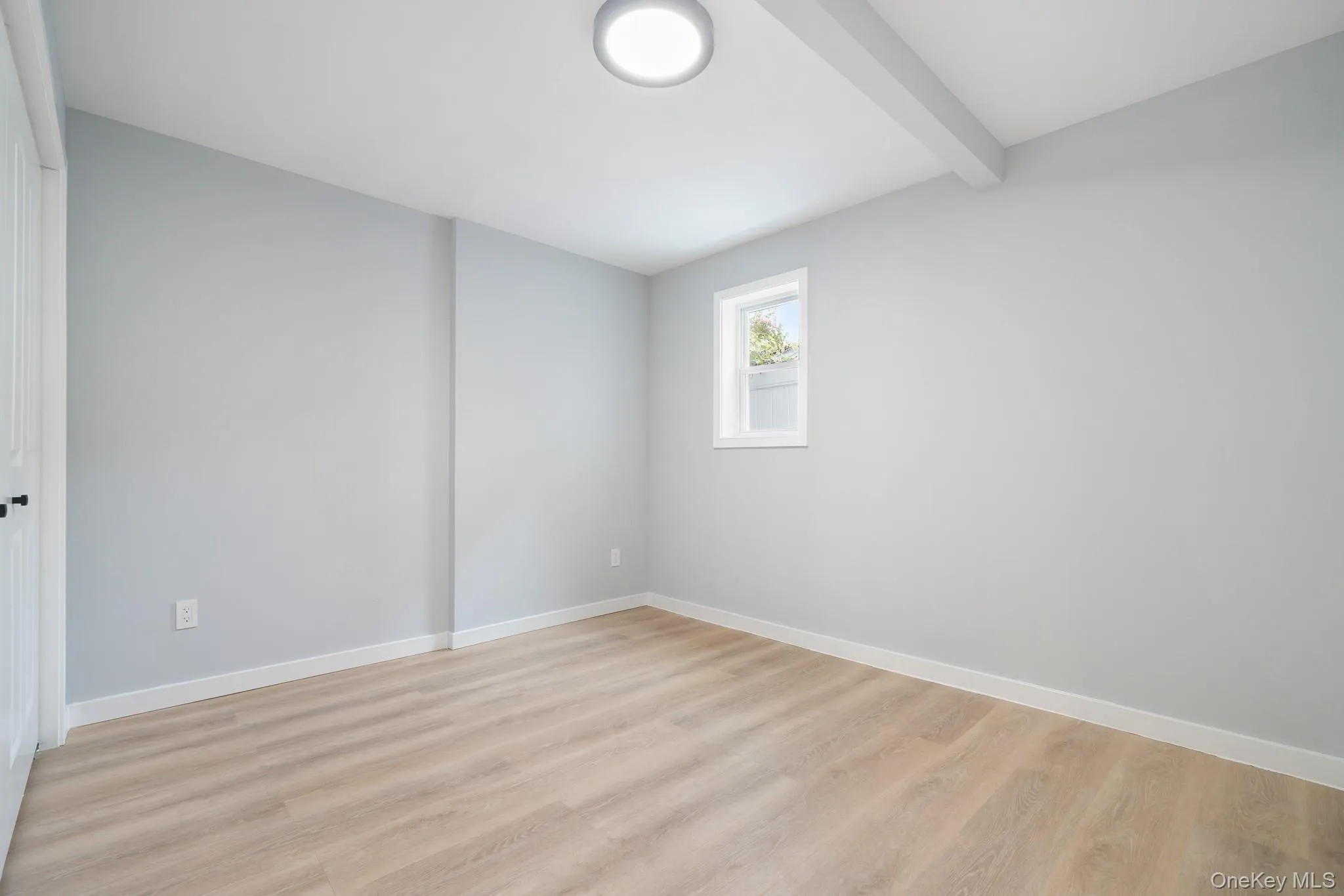 Spare room with beamed ceiling and light wood-style flooring Spare room with beamed ceiling and light wood-style flooring