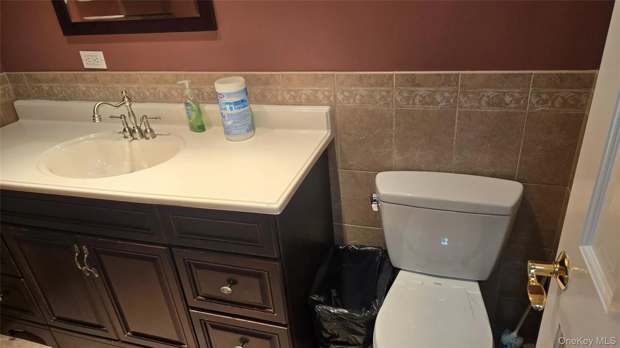 Bathroom featuring vanity, tile walls, and wainscoting Bathroom featuring vanity, tile walls, and wainscoting