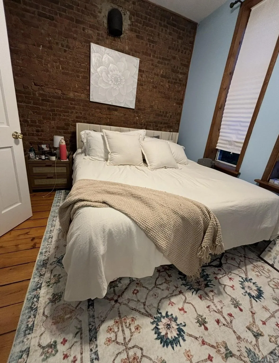 Bedroom with brick wall and wood finished floors Bedroom with brick wall and wood finished floors