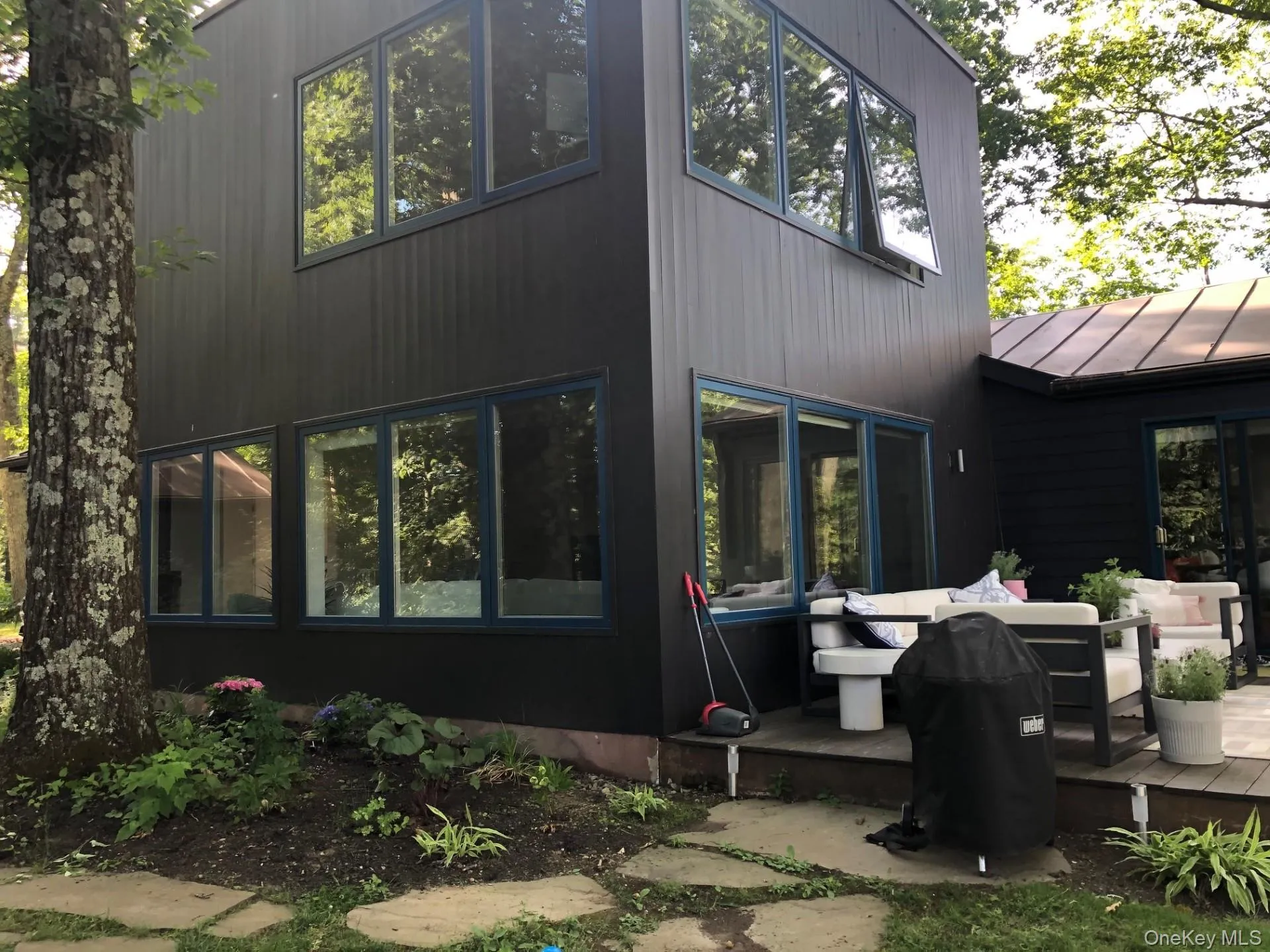 Rear view of house with a standing seam roof, outdoor lounge area and deck Rear view of house with a standing seam roof, outdoor lounge area and deck