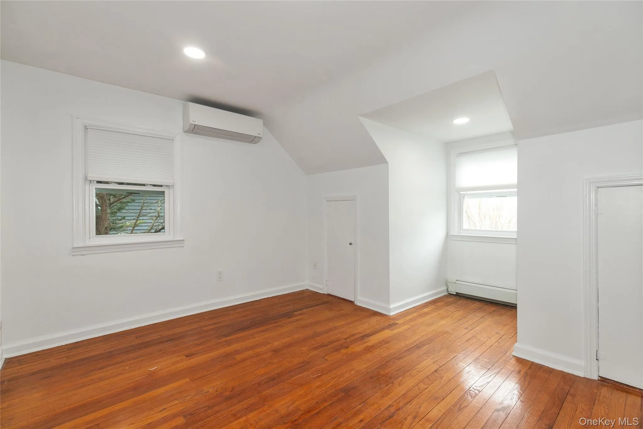Bonus room featuring hardwood / wood-style floors, vaulted ceiling, recessed lighting, plenty of natural light, and a baseboard heating unit Bonus room featuring hardwood / wood-style floors, vaulted ceiling, recessed lighting, plenty of natural light, and a baseboard heating unit