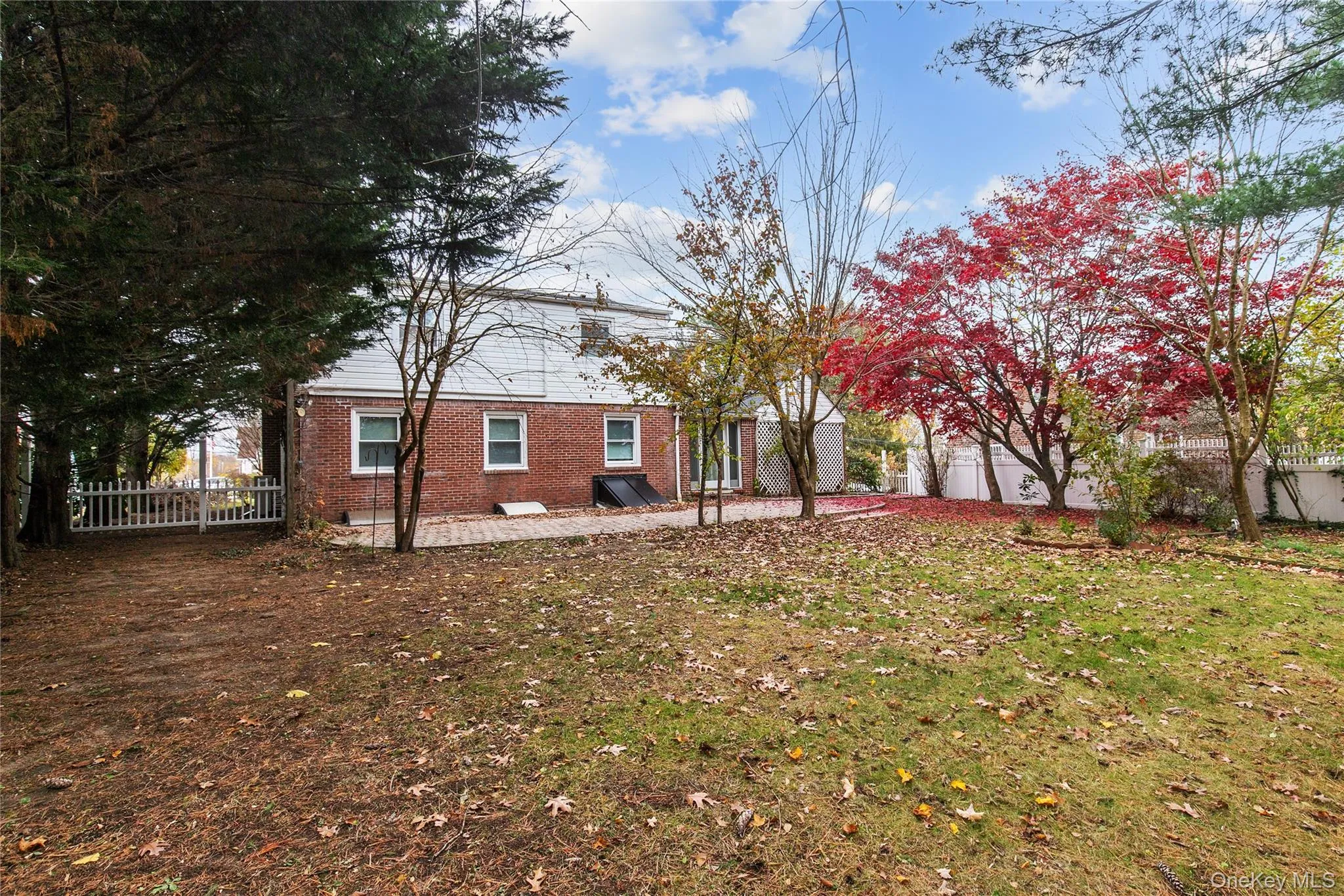 Back of house with a fenced backyard, brick siding, and a patio area Back of house with a fenced backyard, brick siding, and a patio area