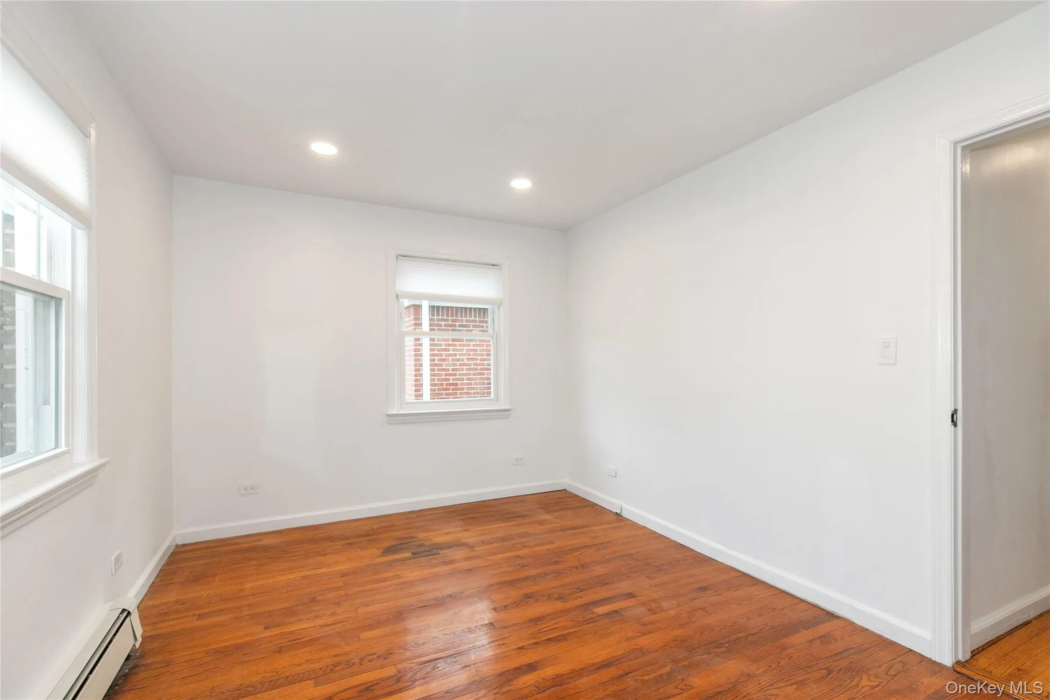 Spare room featuring a baseboard heating unit, hardwood / wood-style flooring, and recessed lighting Spare room featuring a baseboard heating unit, hardwood / wood-style flooring, and recessed lighting