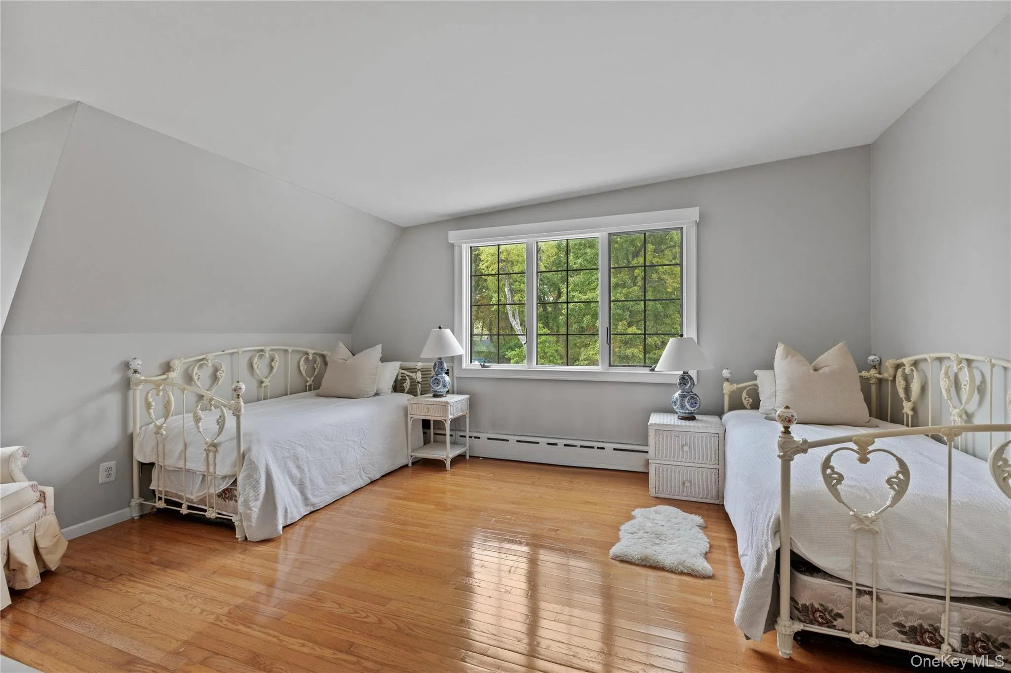 Bedroom with hardwood / wood-style flooring, baseboard heating, and lofted ceiling Bedroom with hardwood / wood-style flooring, baseboard heating, and lofted ceiling