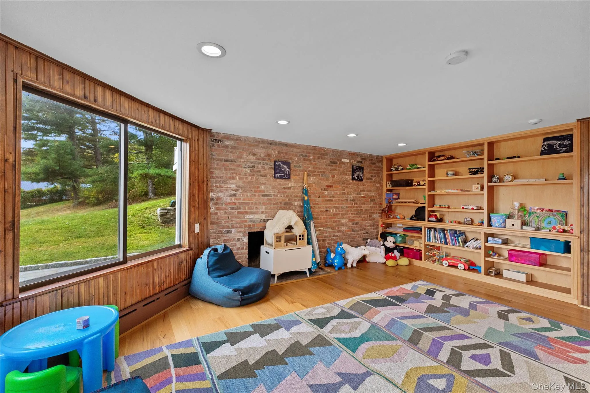 Playroom with light wood-style flooring, a baseboard radiator, recessed lighting, and built in shelves Playroom with light wood-style flooring, a baseboard radiator, recessed lighting, and built in shelves