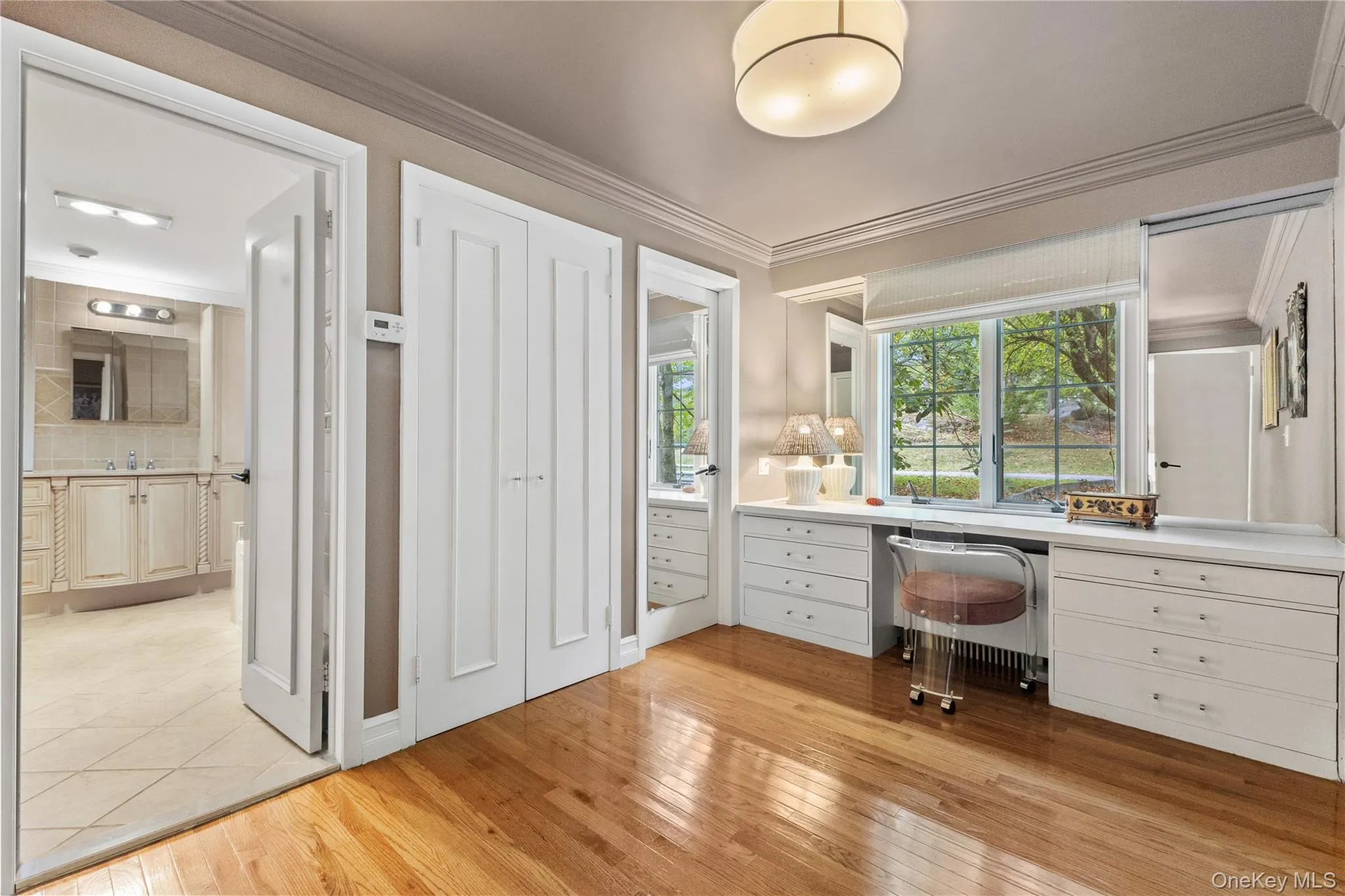 Unfurnished office featuring ornamental molding, light wood-style floors, built in desk, and radiator Unfurnished office featuring ornamental molding, light wood-style floors, built in desk, and radiator