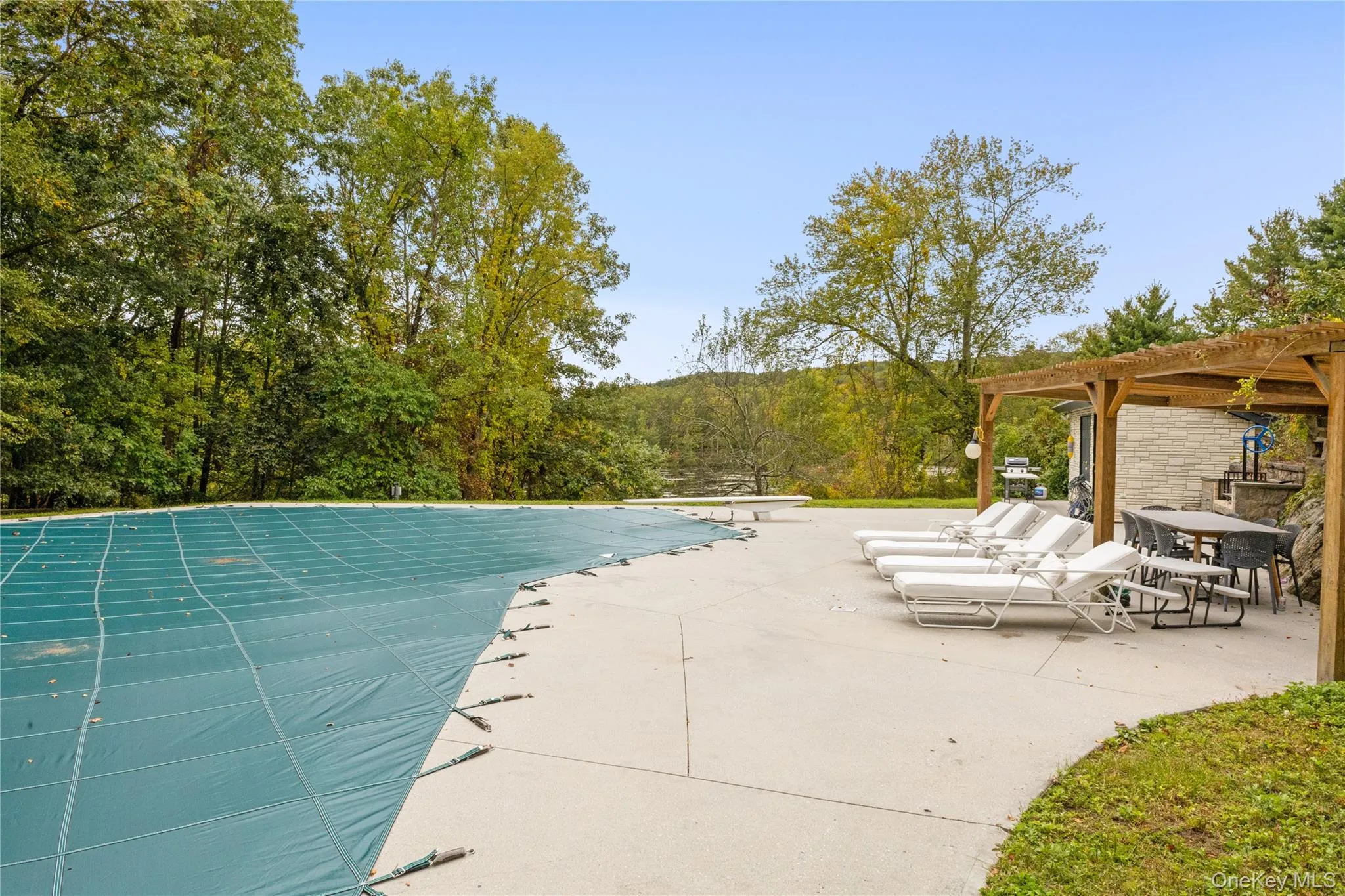 View of swimming pool with a patio, a covered pool, and a pergola View of swimming pool with a patio, a covered pool, and a pergola