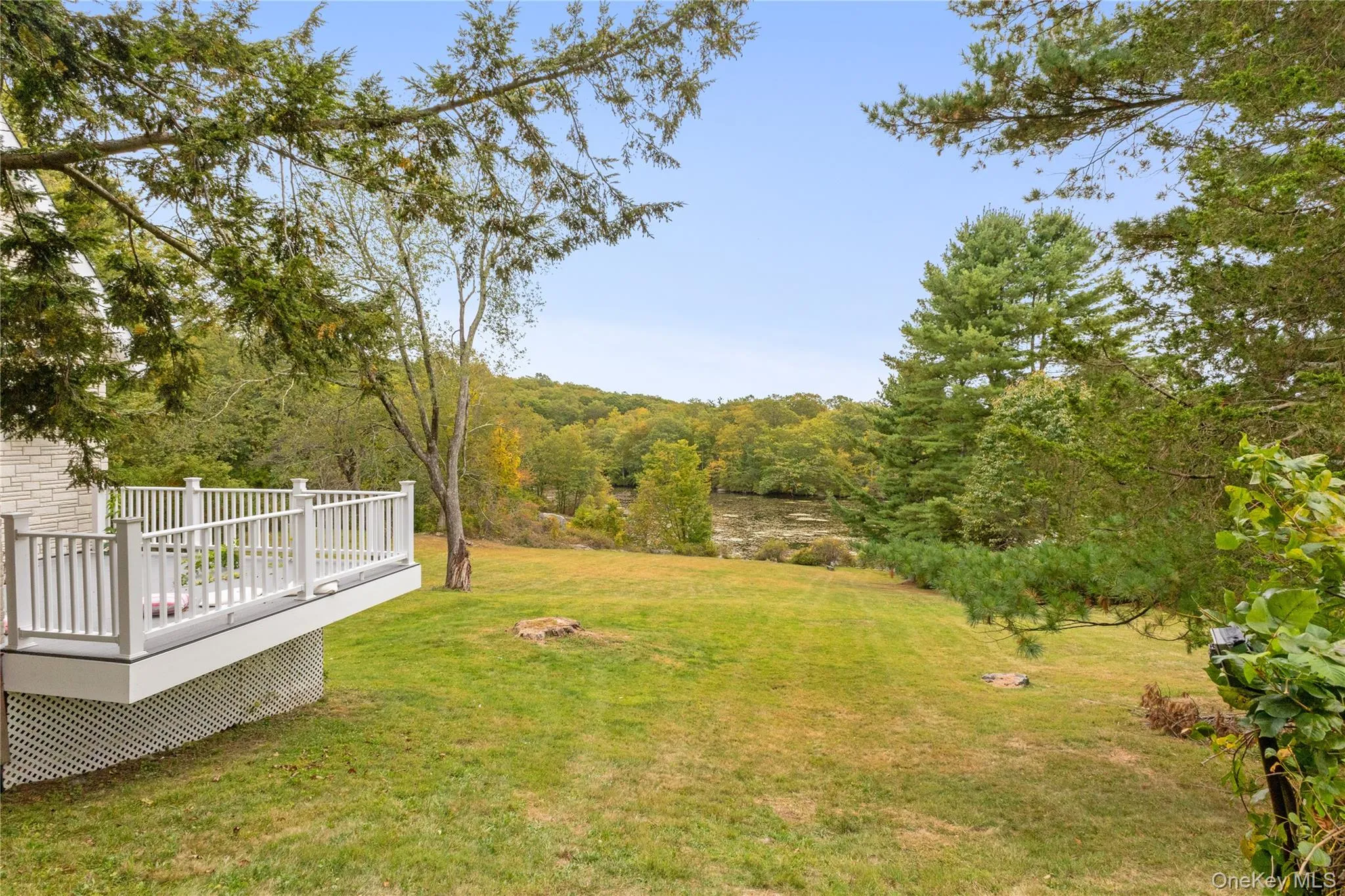 View of green lawn with a wooden deck View of green lawn with a wooden deck
