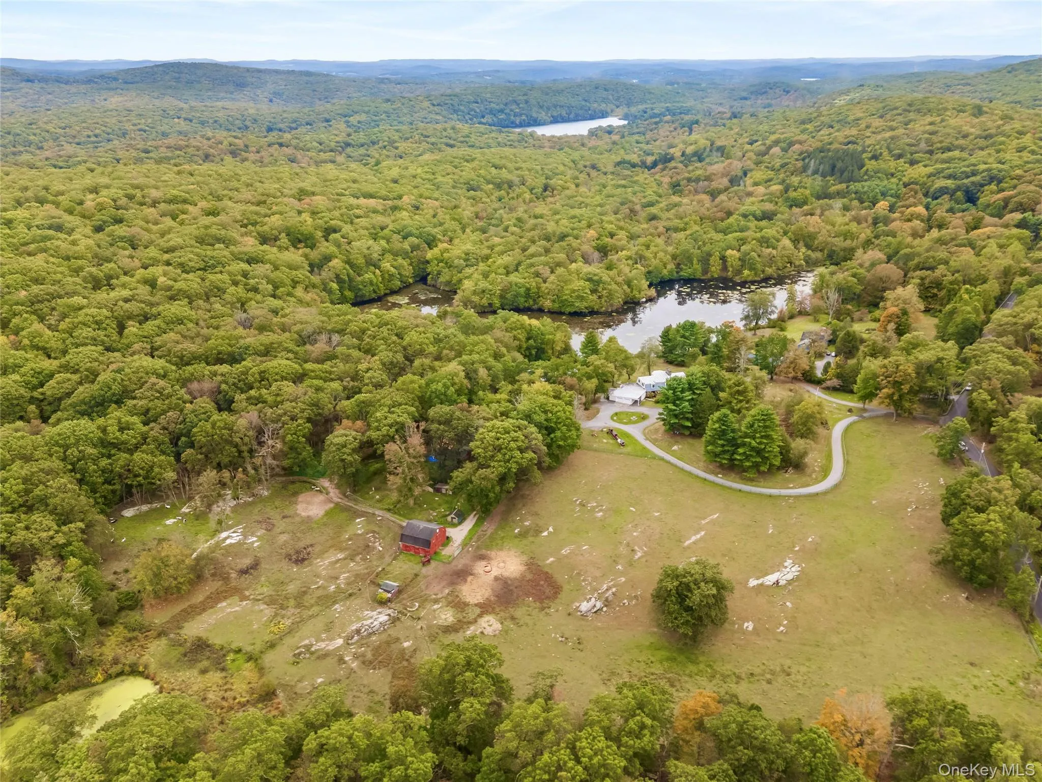 Aerial overview of property's location with a forest and a large body of water Aerial overview of property's location with a forest and a large body of water
