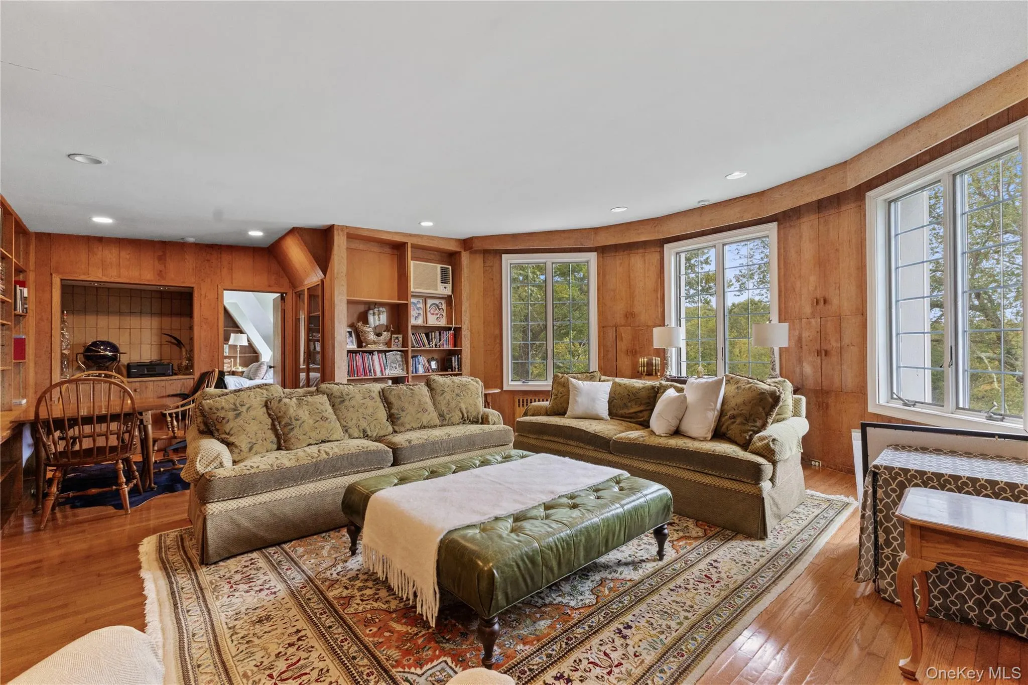Living area featuring wooden walls, wood-type flooring, and recessed lighting Living area featuring wooden walls, wood-type flooring, and recessed lighting