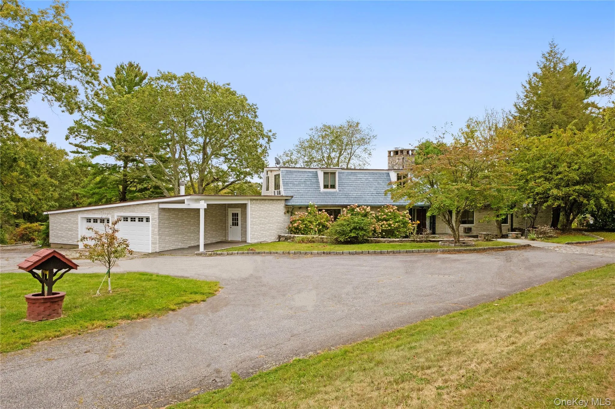 View of front of home with a front lawn, mansard roof, and driveway View of front of home with a front lawn, mansard roof, and driveway