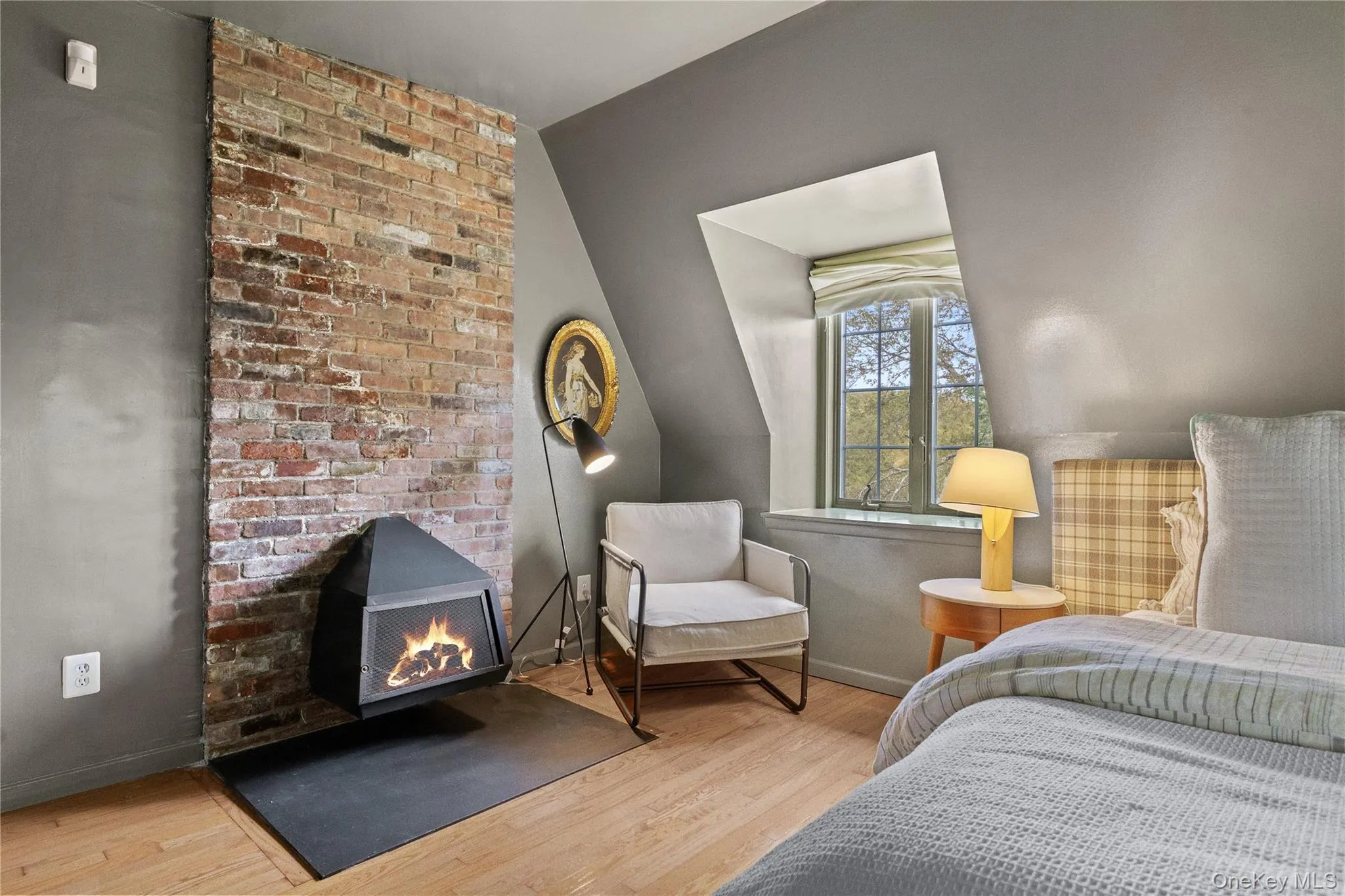 Bedroom with light wood finished floors and a wood stove Bedroom with light wood finished floors and a wood stove