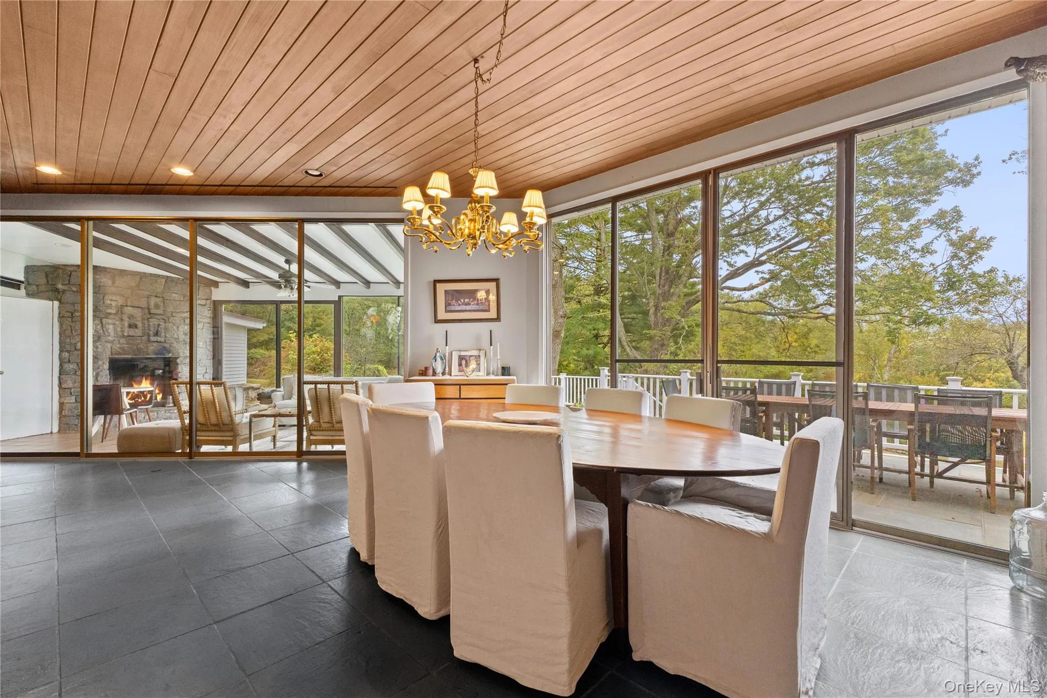 Dining room with a fireplace, a chandelier, and wood ceiling Dining room with a fireplace, a chandelier, and wood ceiling
