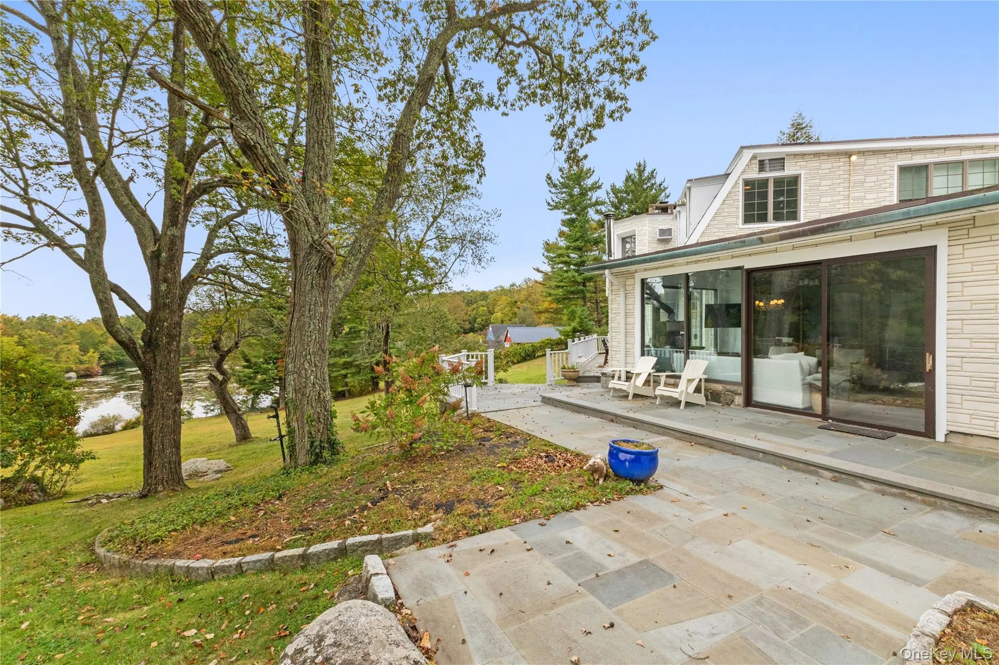 View of green lawn featuring a water view and a patio View of green lawn featuring a water view and a patio