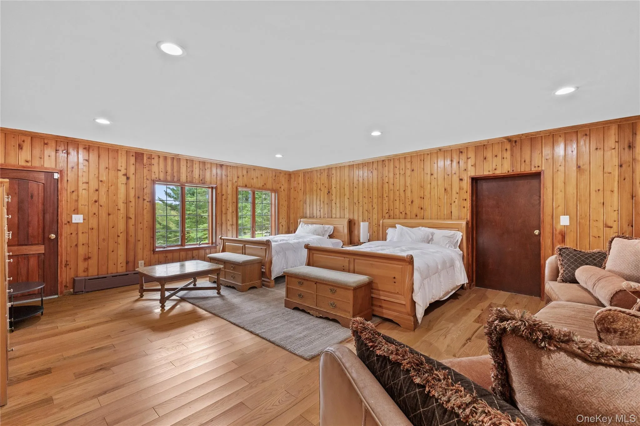Bedroom with light wood-style floors, recessed lighting, ornamental molding, and wood walls Bedroom with light wood-style floors, recessed lighting, ornamental molding, and wood walls