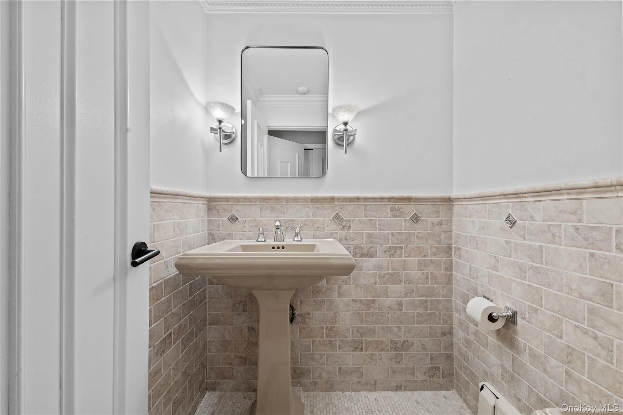 Bathroom featuring tile walls, wainscoting, a baseboard radiator, and ornamental molding Bathroom featuring tile walls, wainscoting, a baseboard radiator, and ornamental molding