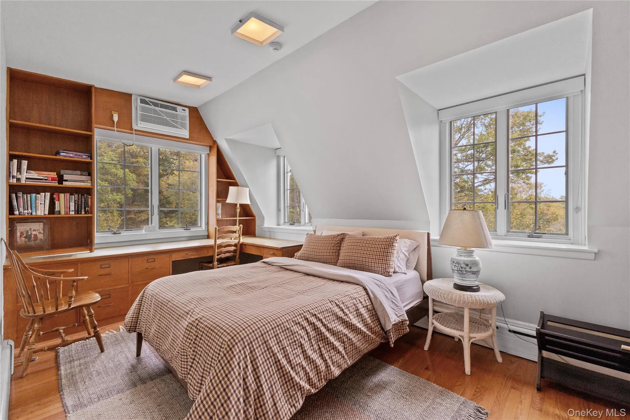 Bedroom featuring light wood-type flooring, lofted ceiling, and a wall unit AC Bedroom featuring light wood-type flooring, lofted ceiling, and a wall unit AC