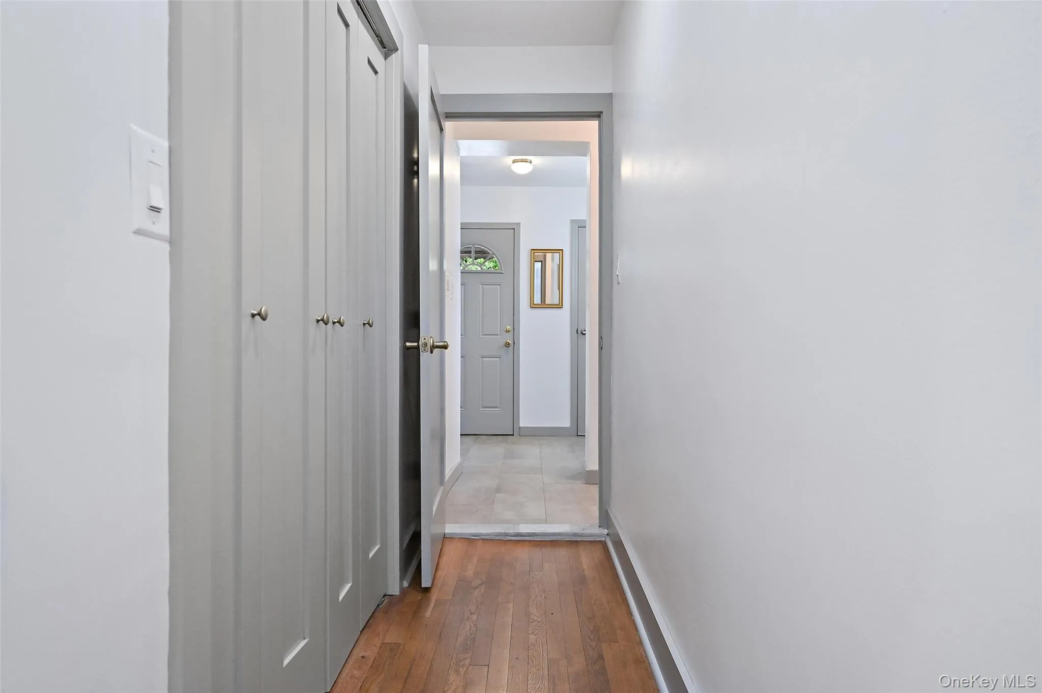 Hallway with dark wood finished floors and baseboards Hallway with dark wood finished floors and baseboards