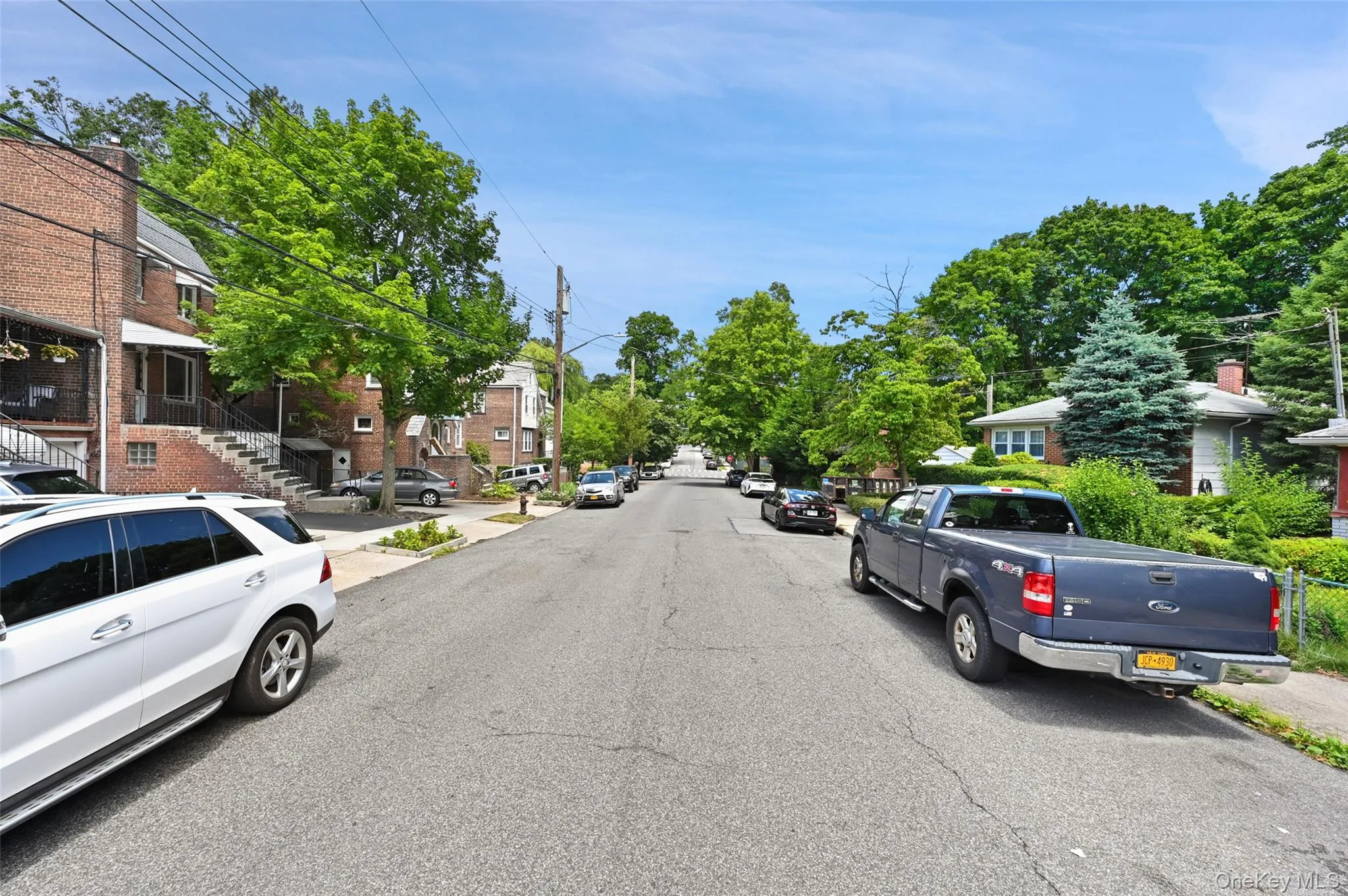 View of asphalt road with sidewalks, curbs, and a residential view View of asphalt road with sidewalks, curbs, and a residential view