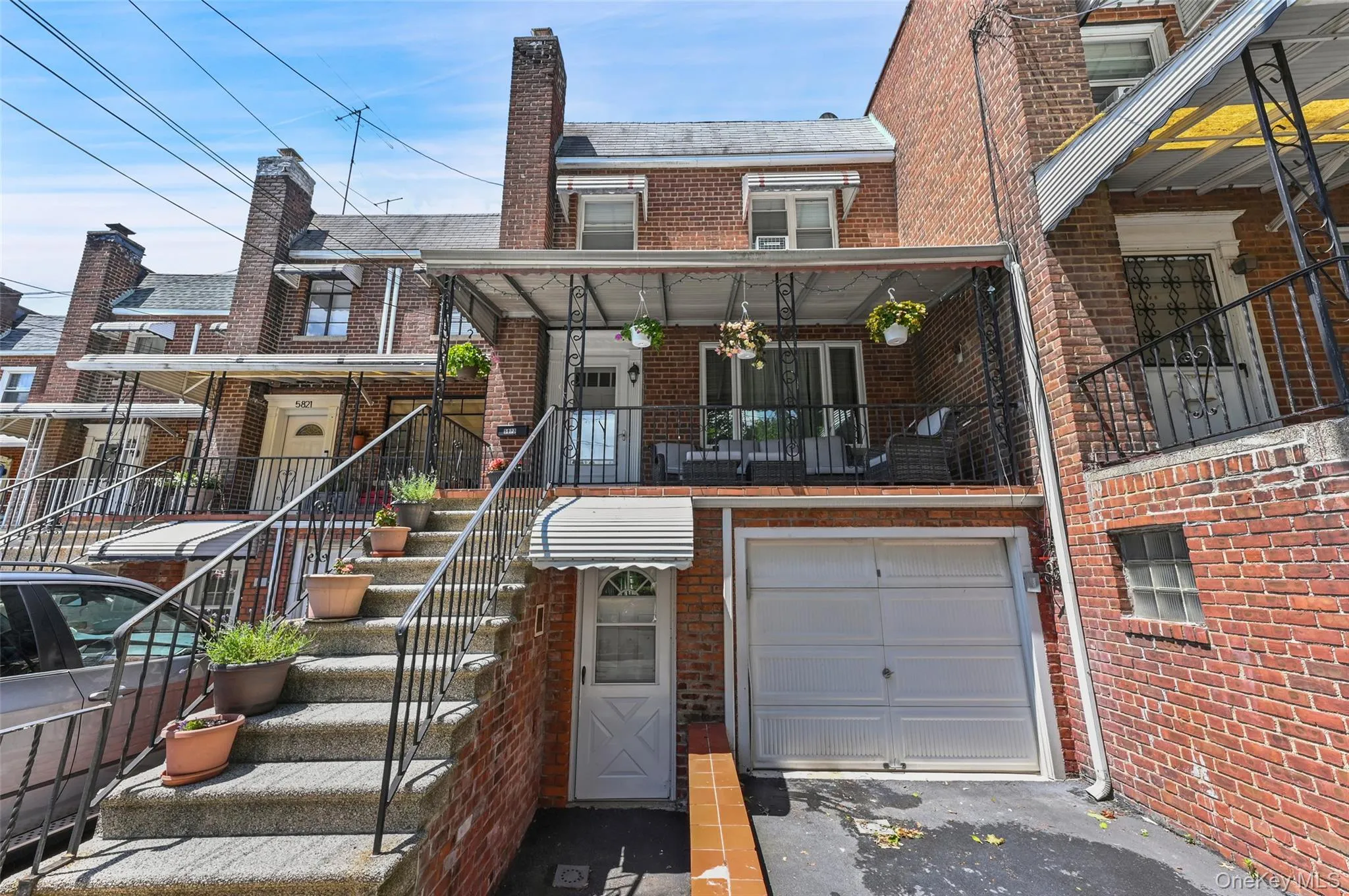 View of front of house featuring brick siding, stairway, a garage, and driveway View of front of house featuring brick siding, stairway, a garage, and driveway