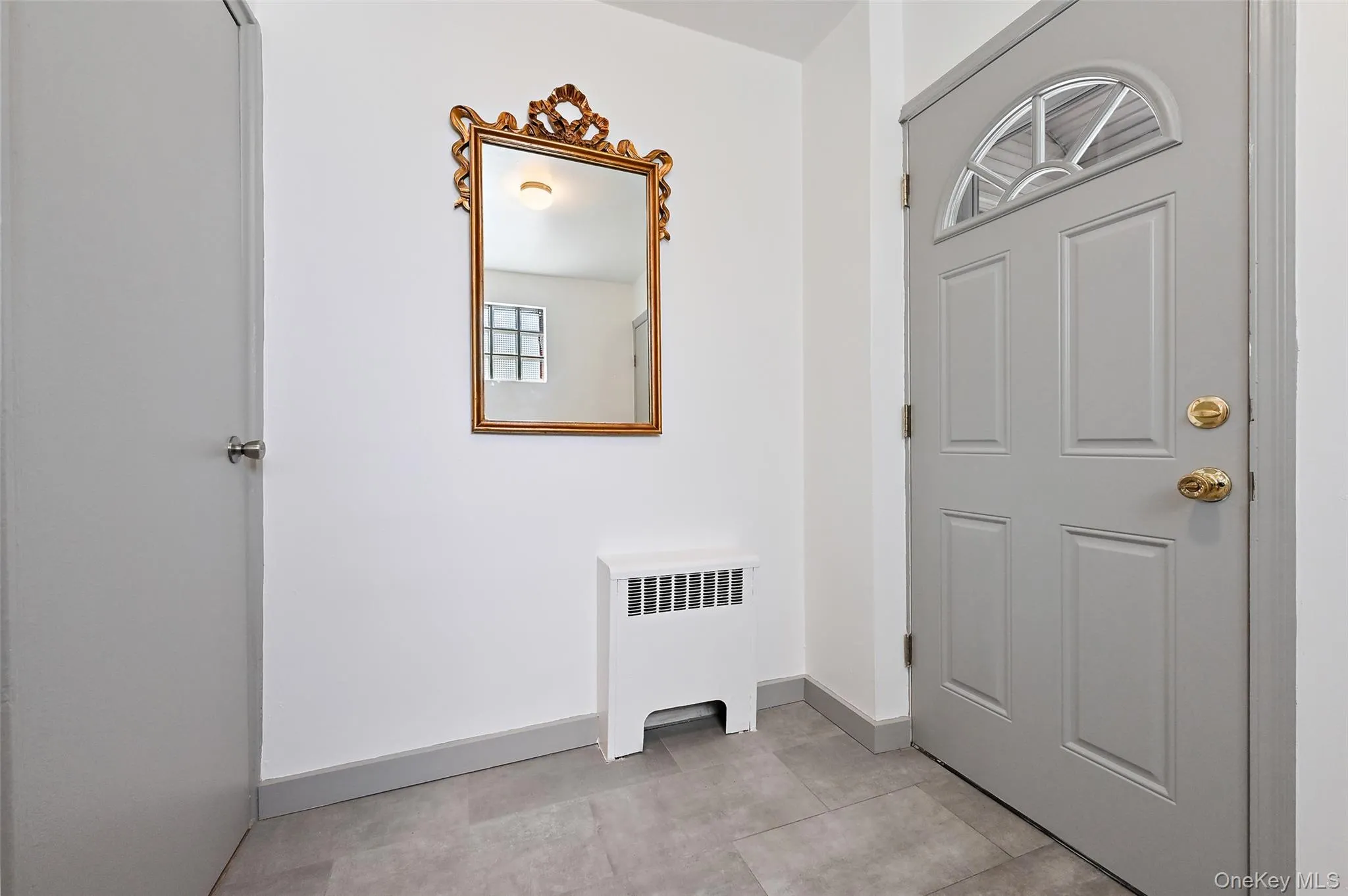 Foyer entrance featuring radiator heating unit and baseboards Foyer entrance featuring radiator heating unit and baseboards