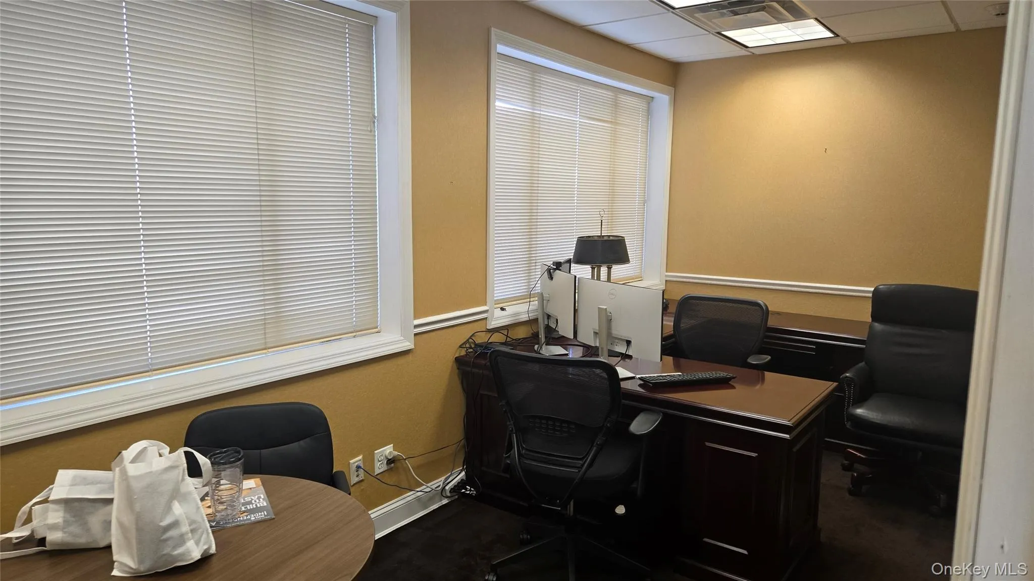 Office area with a drop ceiling and dark carpet Office area with a drop ceiling and dark carpet