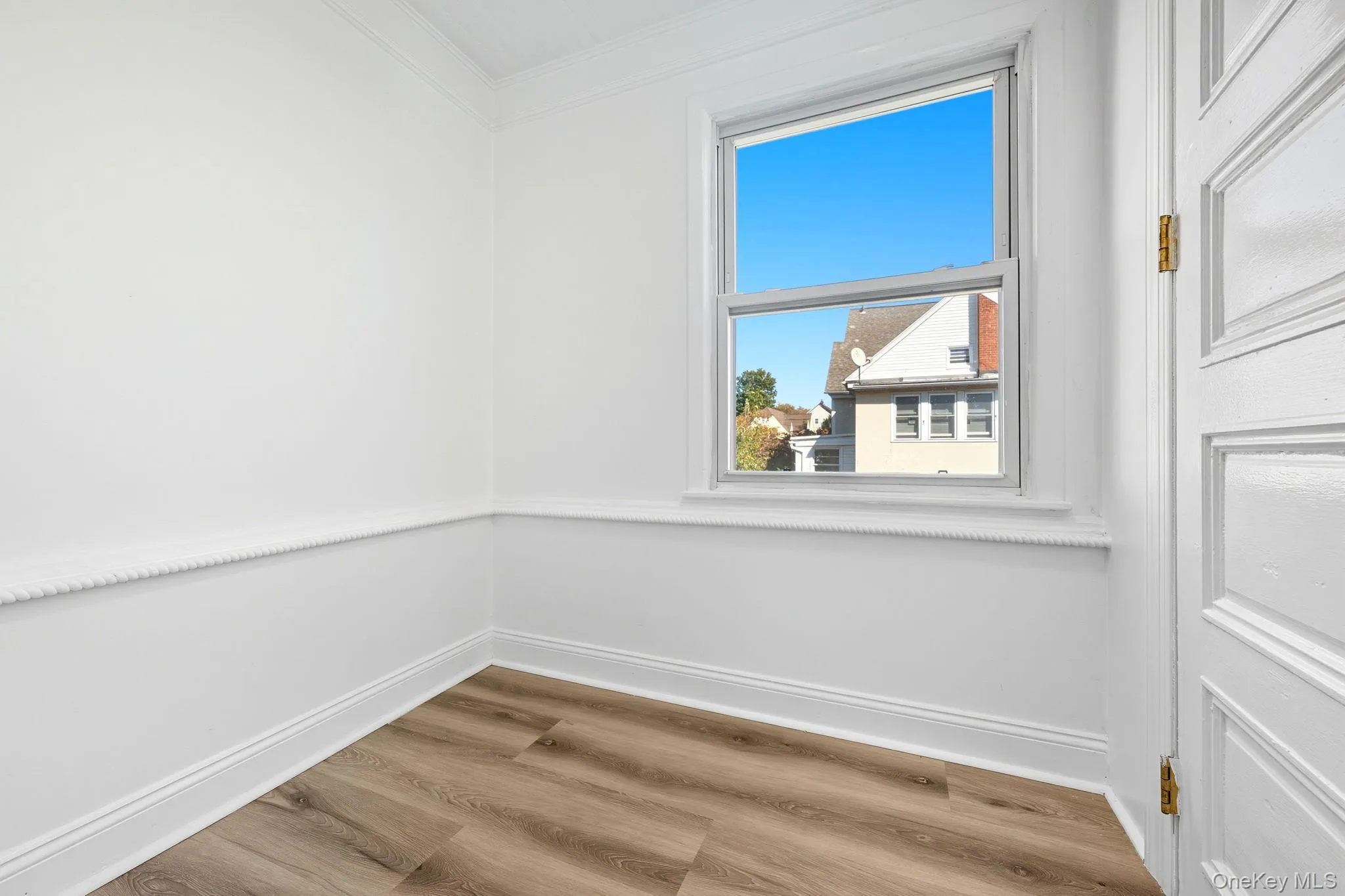 Spare room with light wood-style floors and crown molding Spare room with light wood-style floors and crown molding