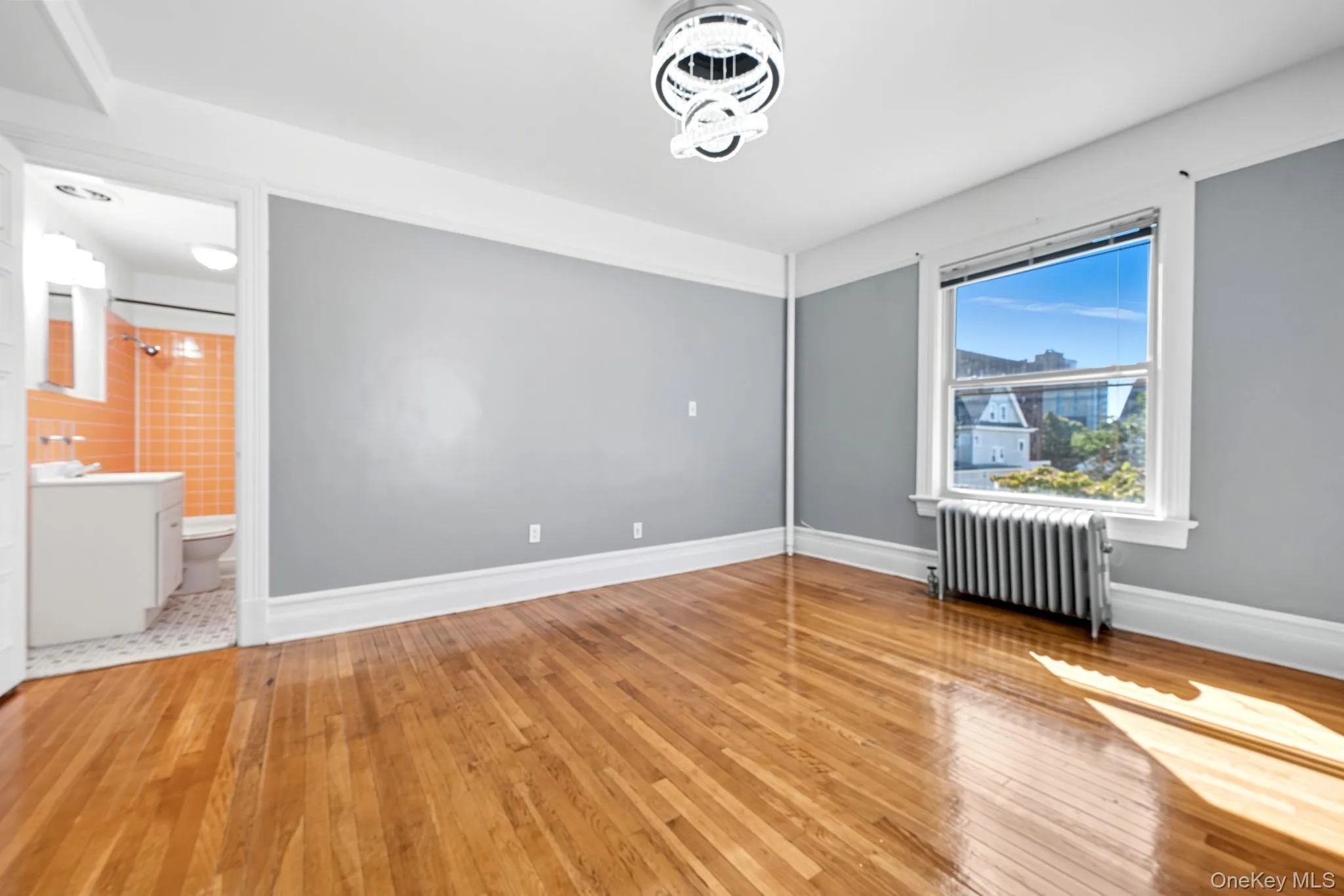 Empty room featuring radiator and light wood-style flooring Empty room featuring radiator and light wood-style flooring