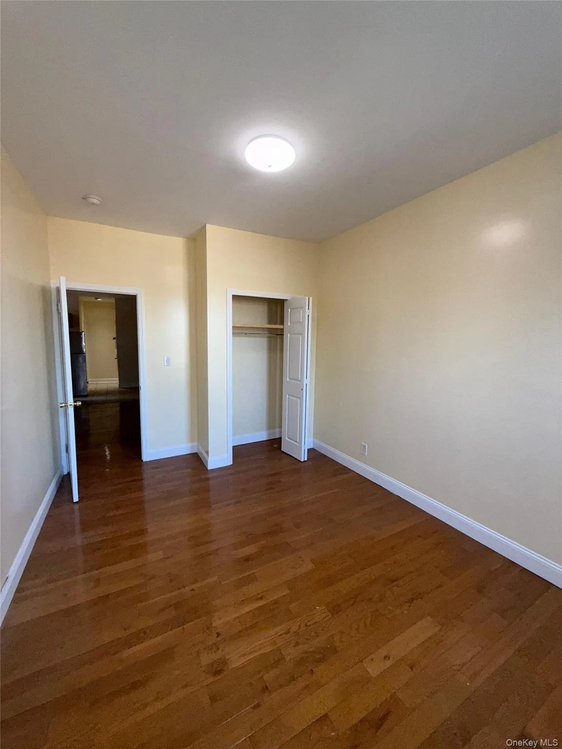 Unfurnished bedroom featuring dark wood-style floors and a closet Unfurnished bedroom featuring dark wood-style floors and a closet