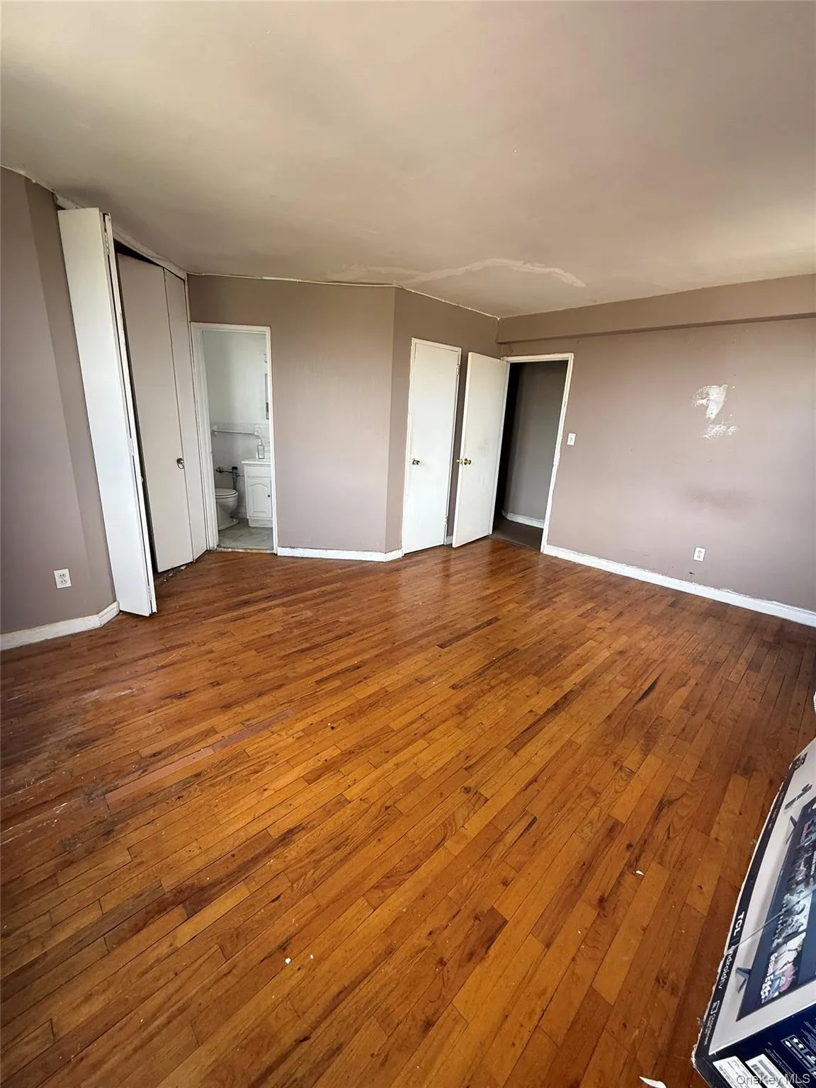Unfurnished bedroom with hardwood / wood-style floors and connected bathroom Unfurnished bedroom with hardwood / wood-style floors and connected bathroom