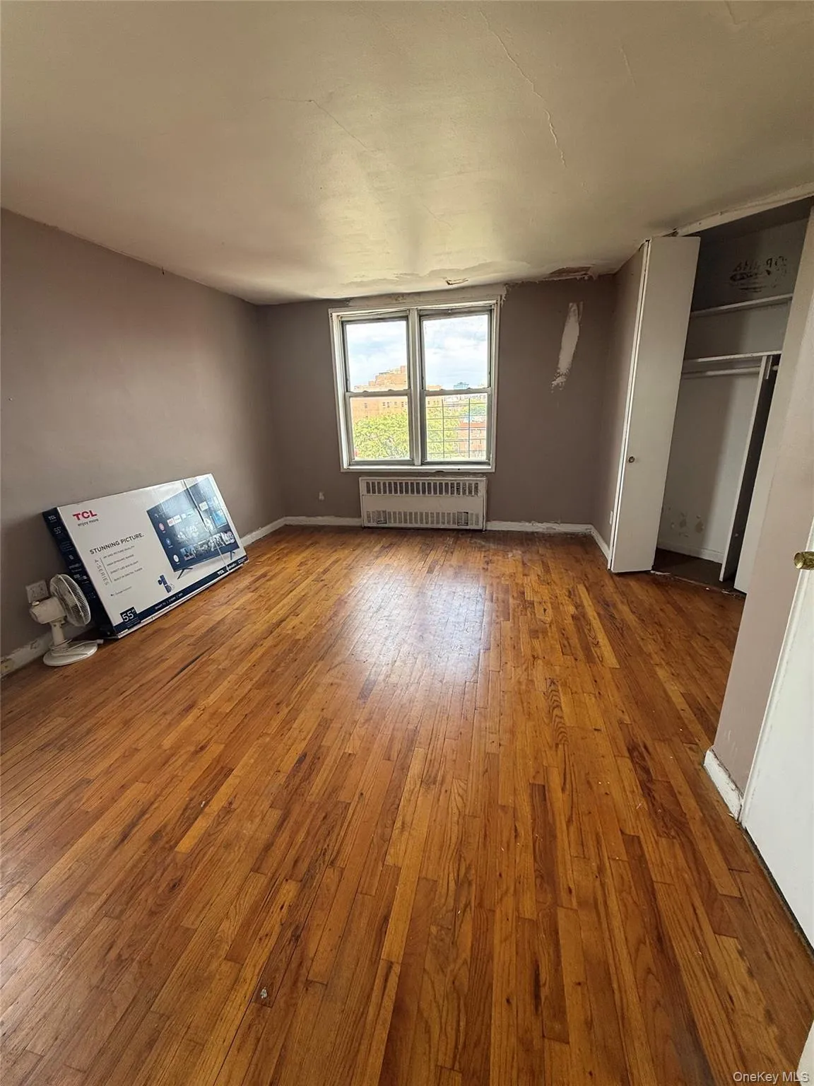 Unfurnished living room featuring light wood-style floors and radiator Unfurnished living room featuring light wood-style floors and radiator