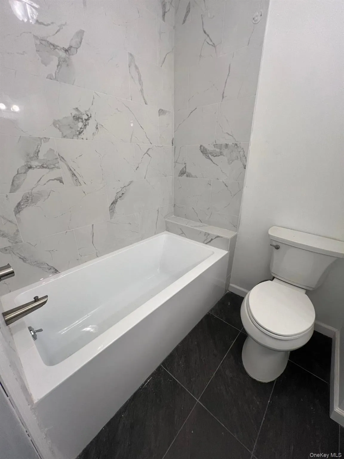 Bathroom featuring tile patterned flooring and bathtub / shower combination Bathroom featuring tile patterned flooring and bathtub / shower combination