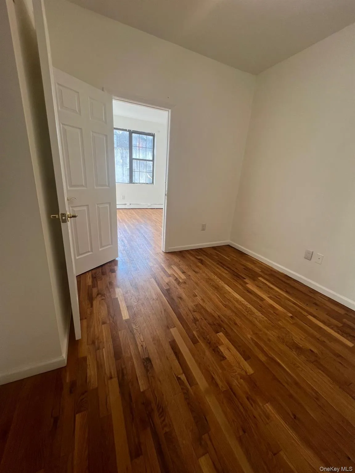 Spare room with baseboards and dark wood-style floors Spare room with baseboards and dark wood-style floors