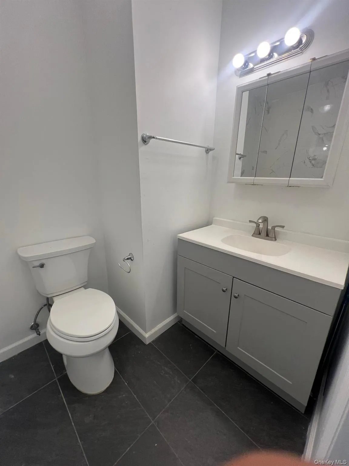 Bathroom featuring vanity and dark tile patterned floors Bathroom featuring vanity and dark tile patterned floors