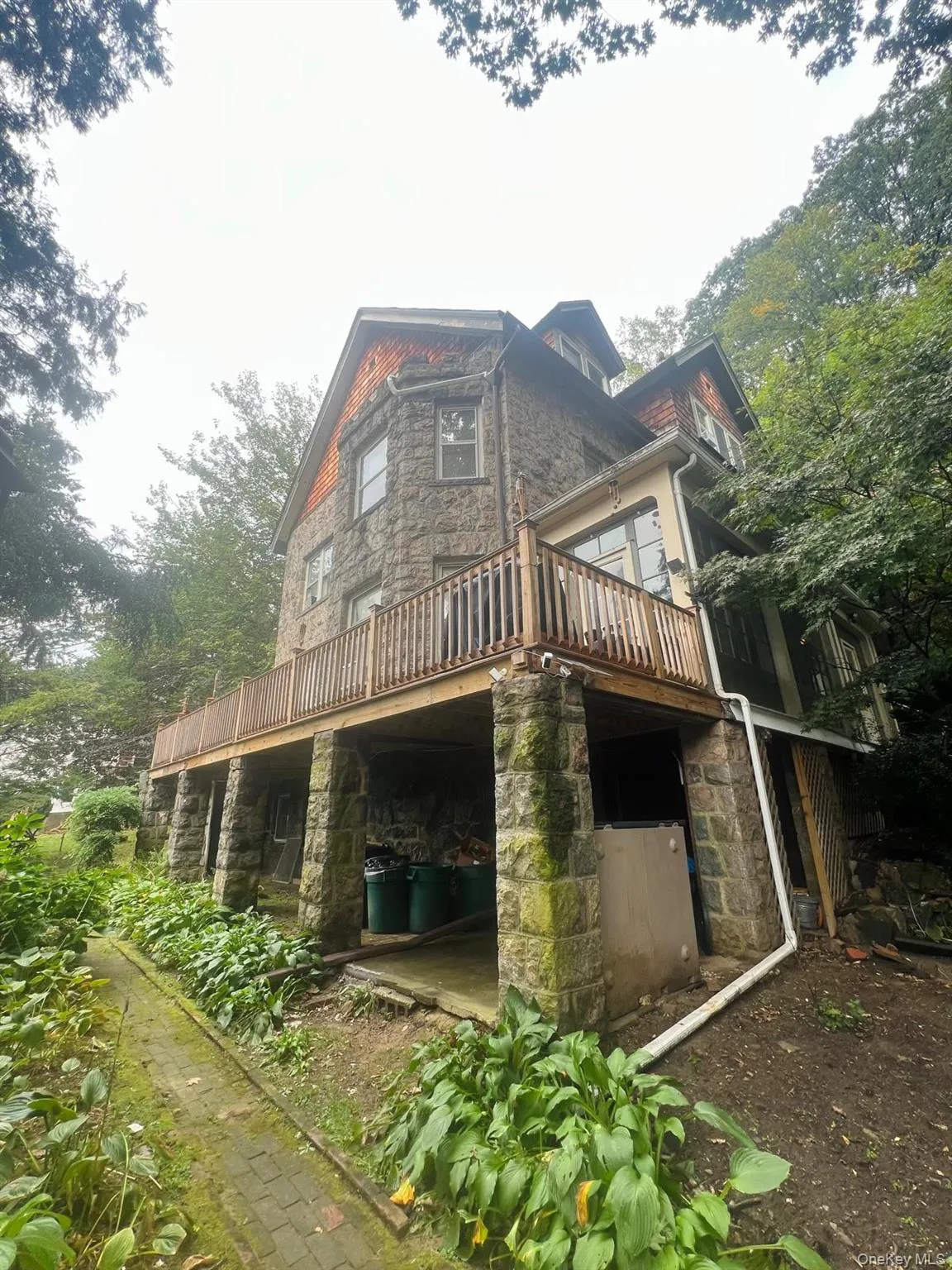 Rear view of house with a wooden deck and stone siding Rear view of house with a wooden deck and stone siding