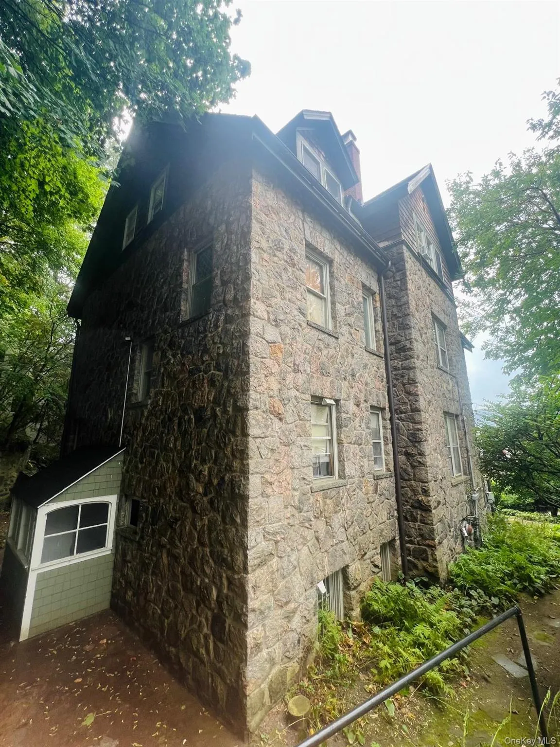 View of side of property featuring stone siding and a chimney View of side of property featuring stone siding and a chimney