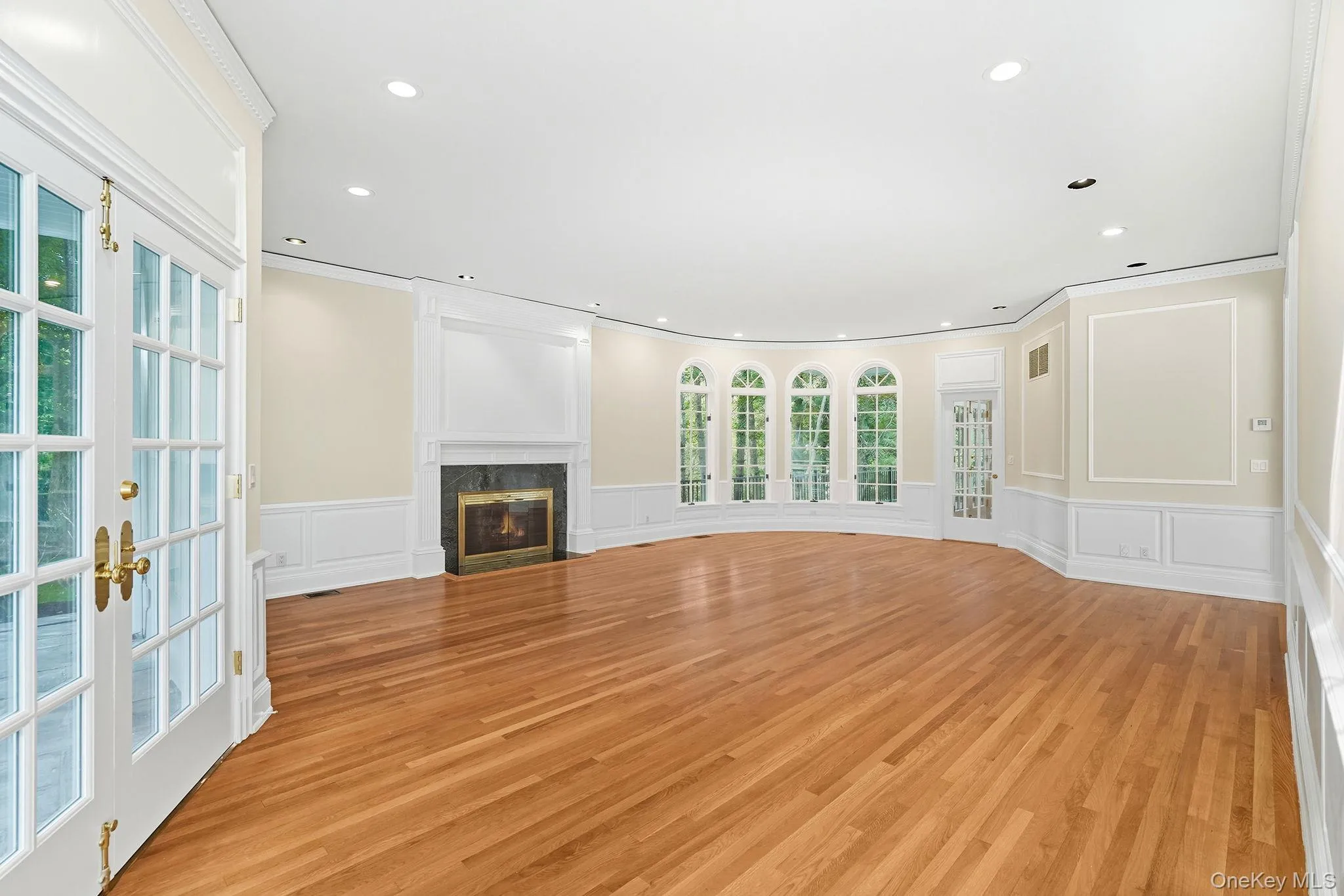 Elegant impressive living room with a wood burning fireplace with french doors opening to the terrace, pool and magnificent lush private grounds Elegant impressive living room with a wood burning fireplace with french doors opening to the terrace, pool and magnificent lush private grounds